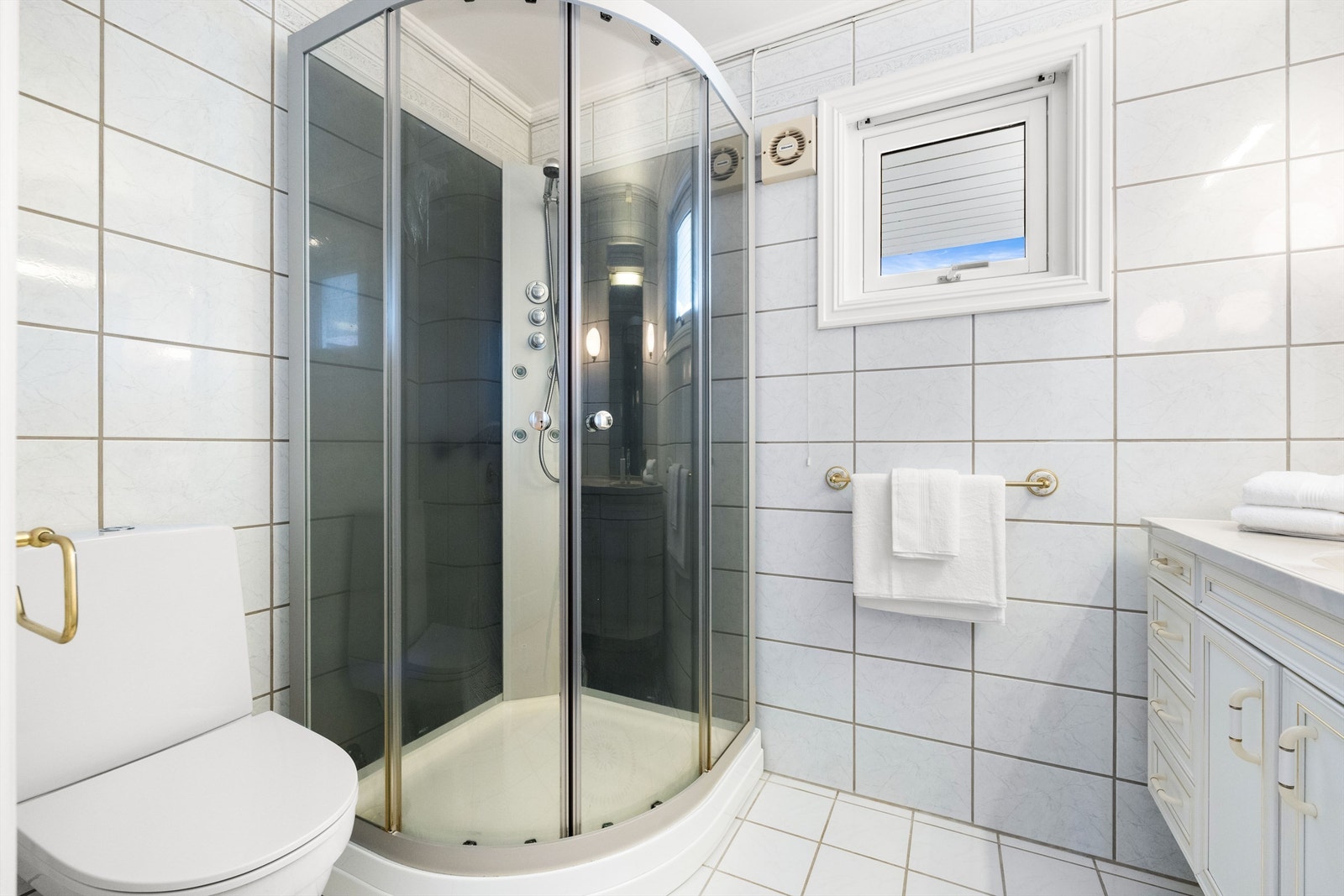 Videre har baderommet innredning med servant, speil, toalett og dusjkabinett. Galleribilde