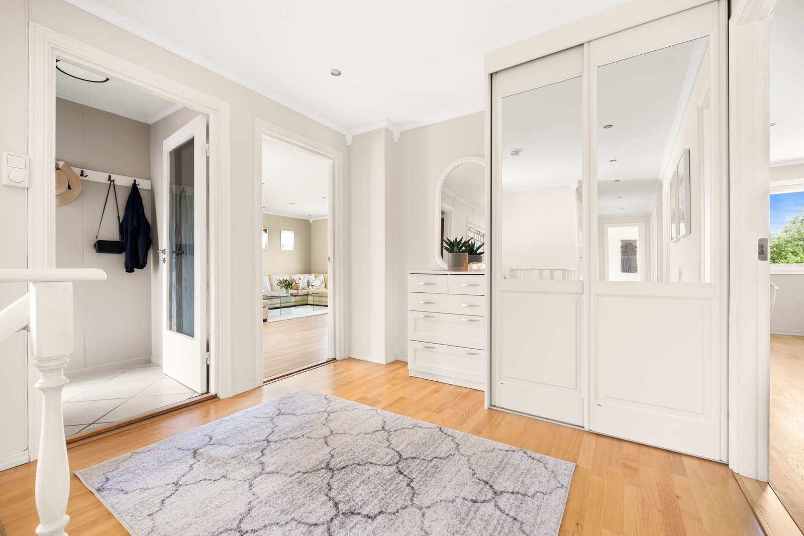 Videre inn i hall, som binder hele boligen sammen. Hallen har plass til kommode for oppbevaring, samt oppheng for klær og sko i garderobeskap. Galleribilde