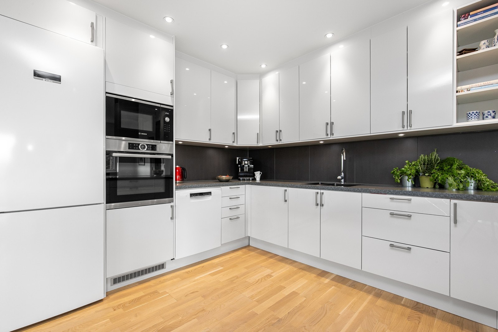 Praktisk med takhøye skap, godt med lagring og fliser over benk. Galleribilde