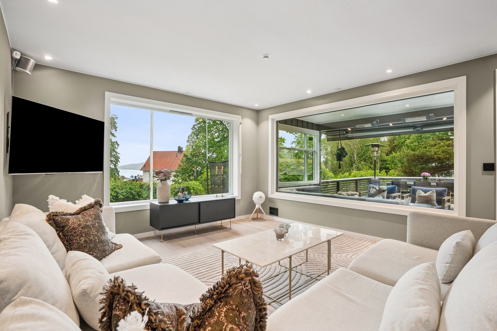 Stuen har store vindusflater som slipper rikelig med naturlig lys inn i rommet fra flere sider. Galleribilde