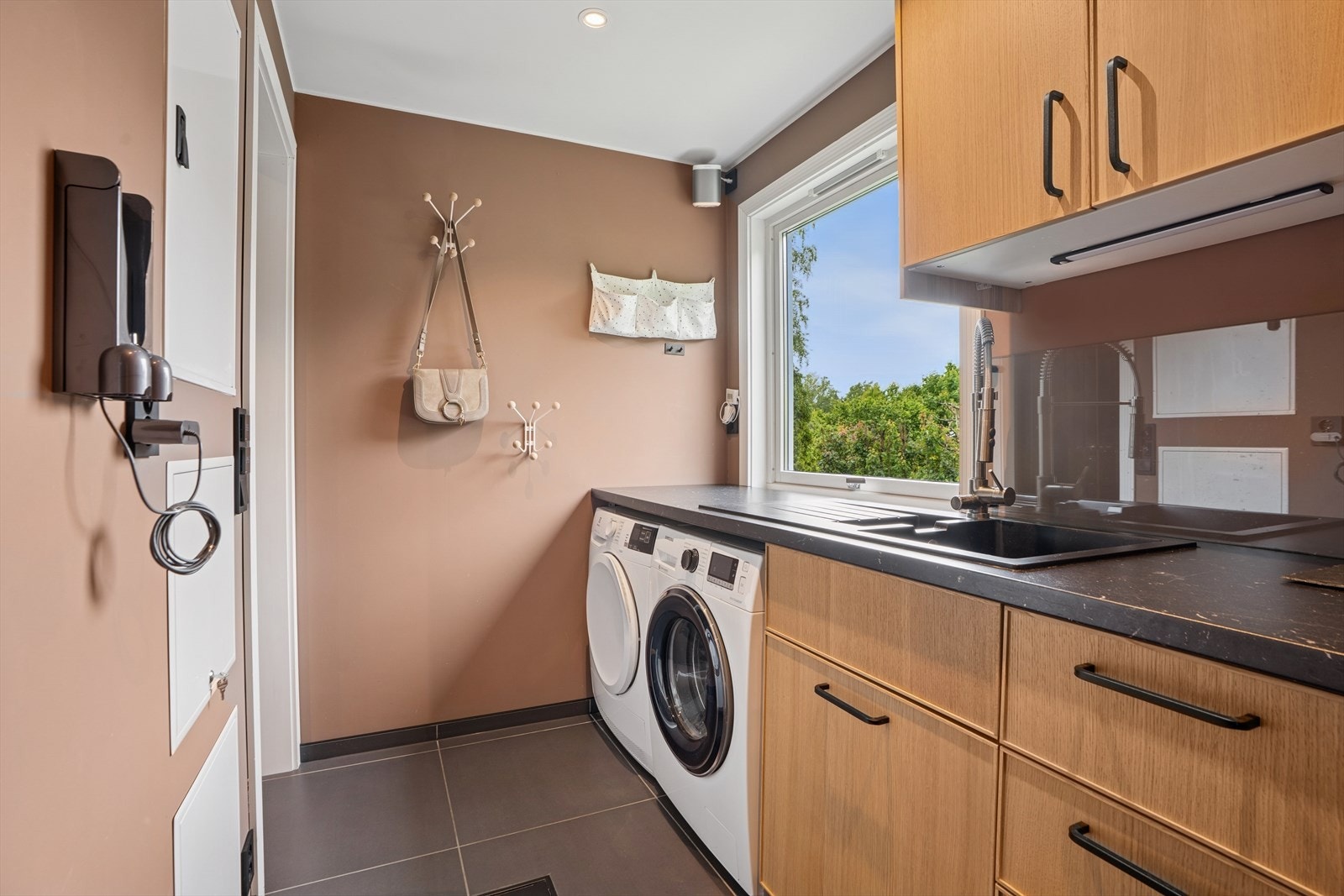 Vaskerommet i 1. etasje er utstyrt med benkeinnredning fra 2019 og har god skapplass, en utslagsvask og en praktisk benkeplate. Galleribilde