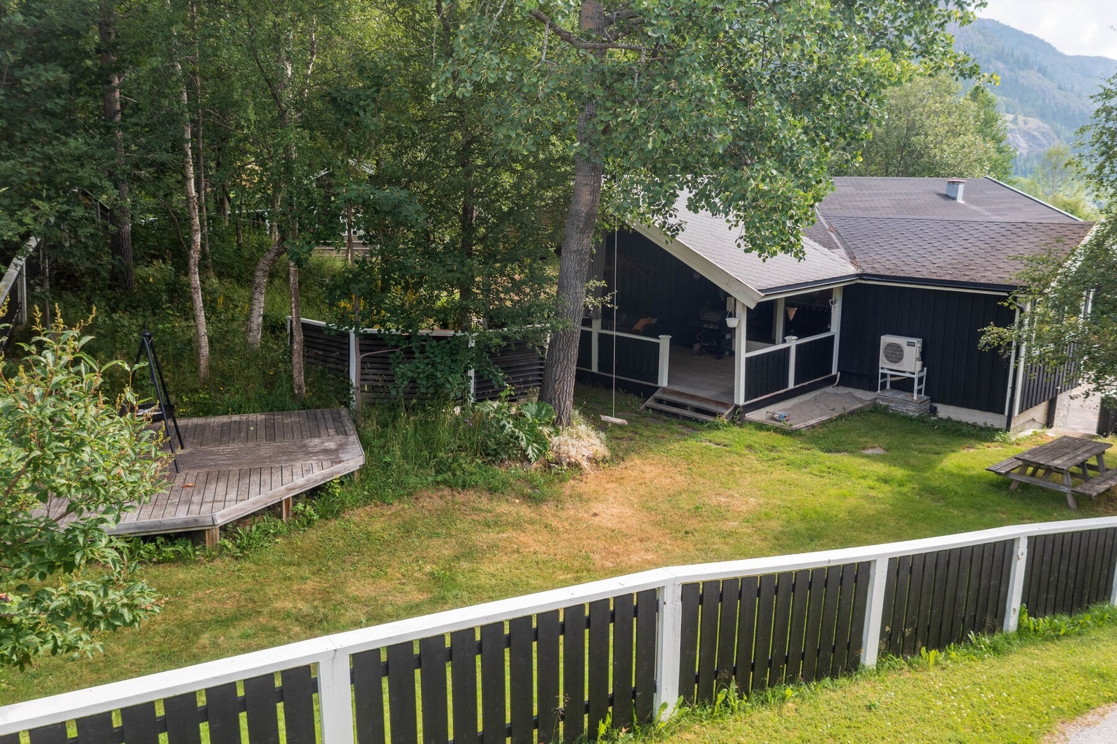 Sommerbilde: Stor hage delt inn i flere soner og plan. Galleribilde