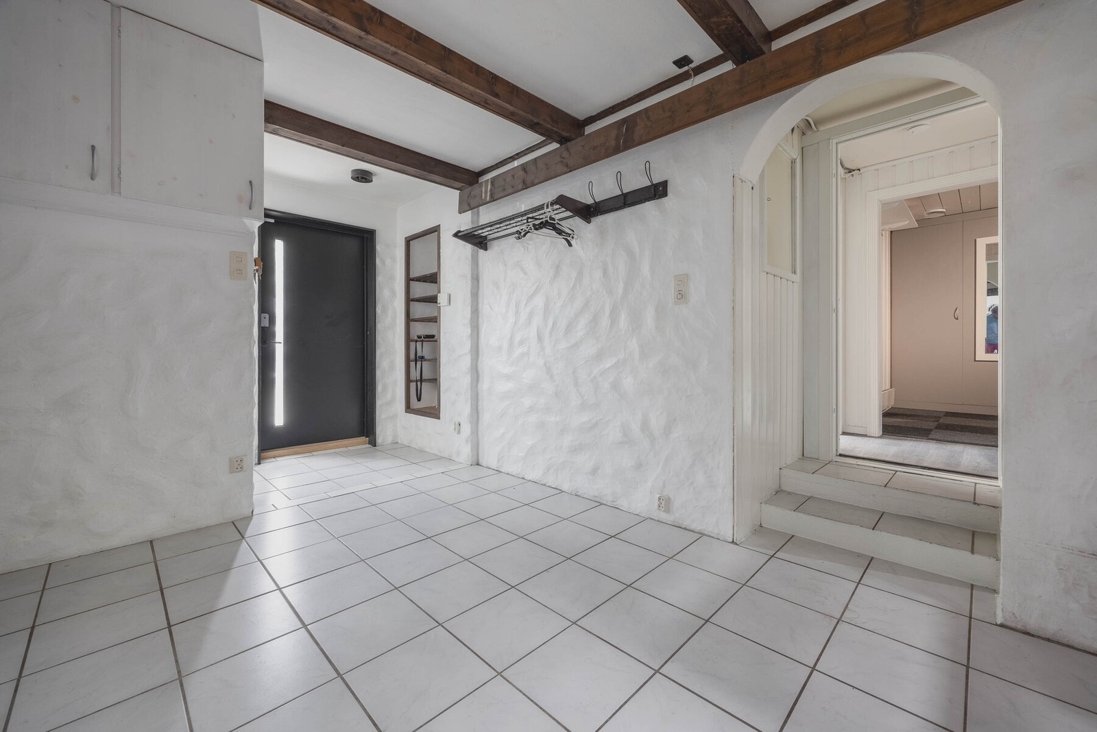 Innbydende entré med flislagt gulv og synlige bjelker. Galleribilde