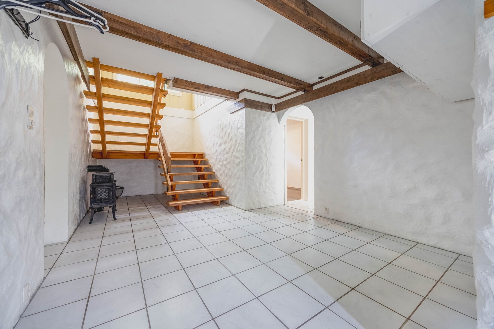 Hall/trappegang med flotte trebjelker og jøtul peisovn. Galleribilde