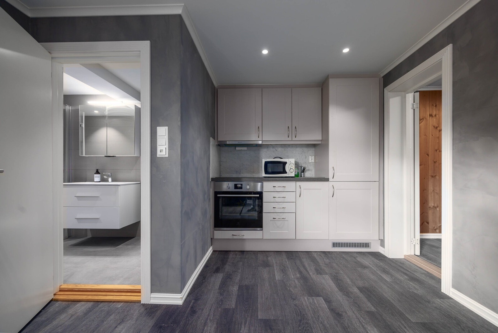 Moderne kjøkken i delikat gråtone med integrerte løsninger. Galleribilde