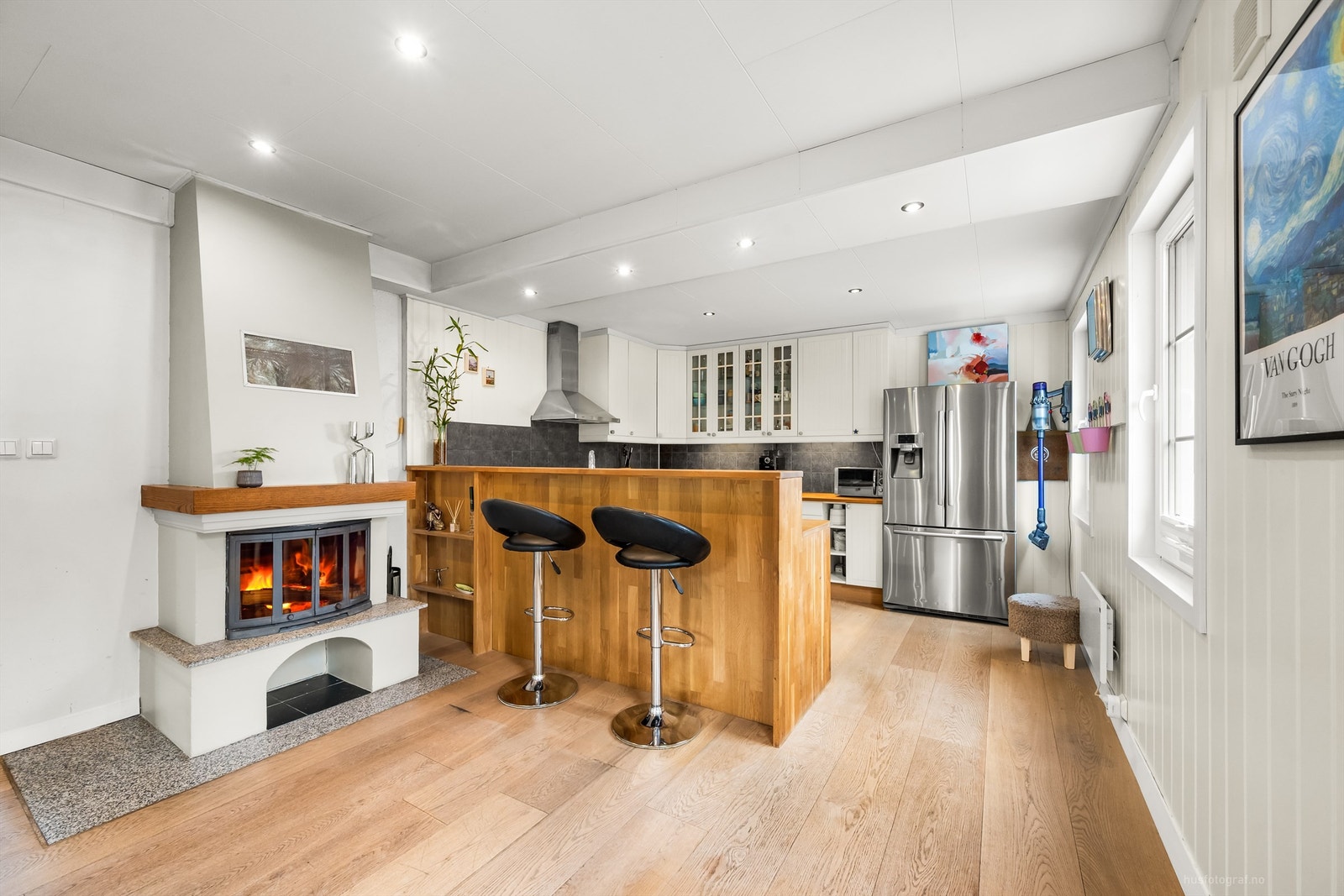 Profilert kjøkkeninnredning med delvis integrerte hvitevarer og praktisk barløsning Galleribilde