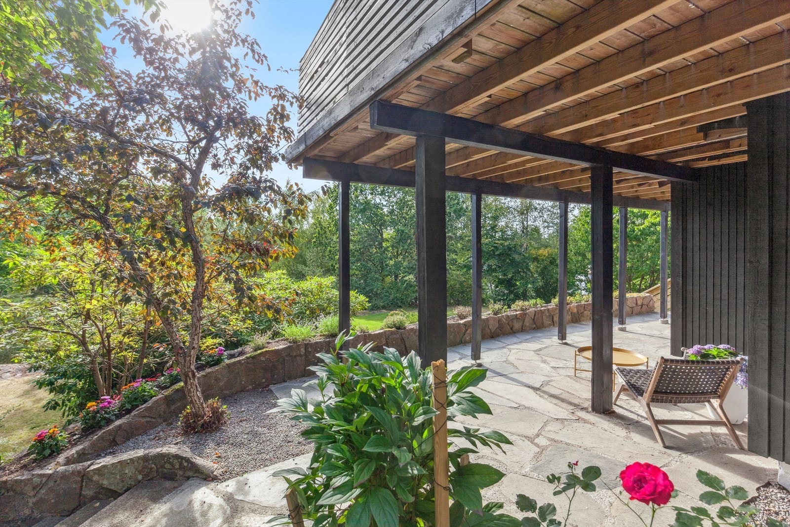 Flere nydelige uteplasser med skifer, trapper, helleganger og sitteplass under terrassen. Galleribilde