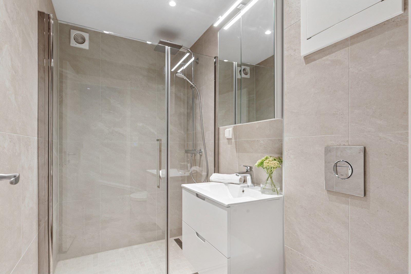 Innbydende helfliset bad fra 2019. Rommet har baderomsinnredning med servant og bl. batteri, speil, lys, dusjhjørne med glassdør og vegghengt toalett. Sanitærutstyr og innredning fra 2019. Elektronisk styrt vifte fra våtrom. Galleribilde