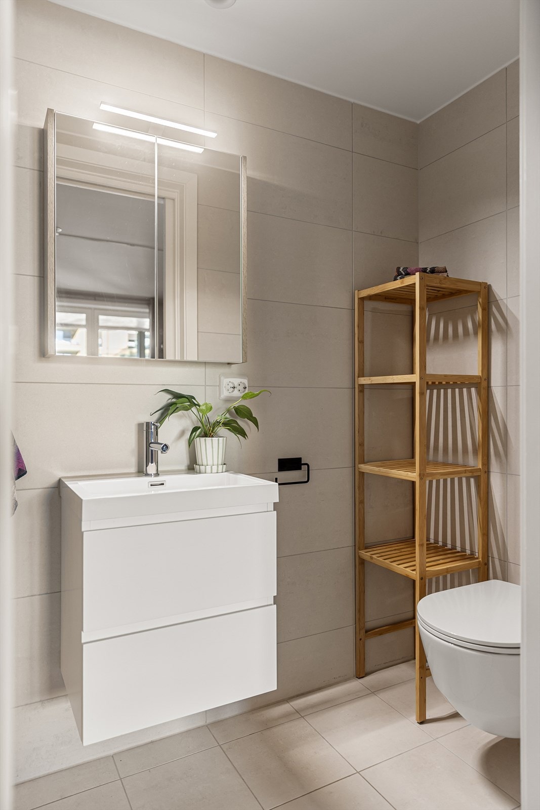 Badet er utstyrt med vegghengt wc, servant med skuffer under, speilskap over og dusj i hjørne med glassdør. Galleribilde