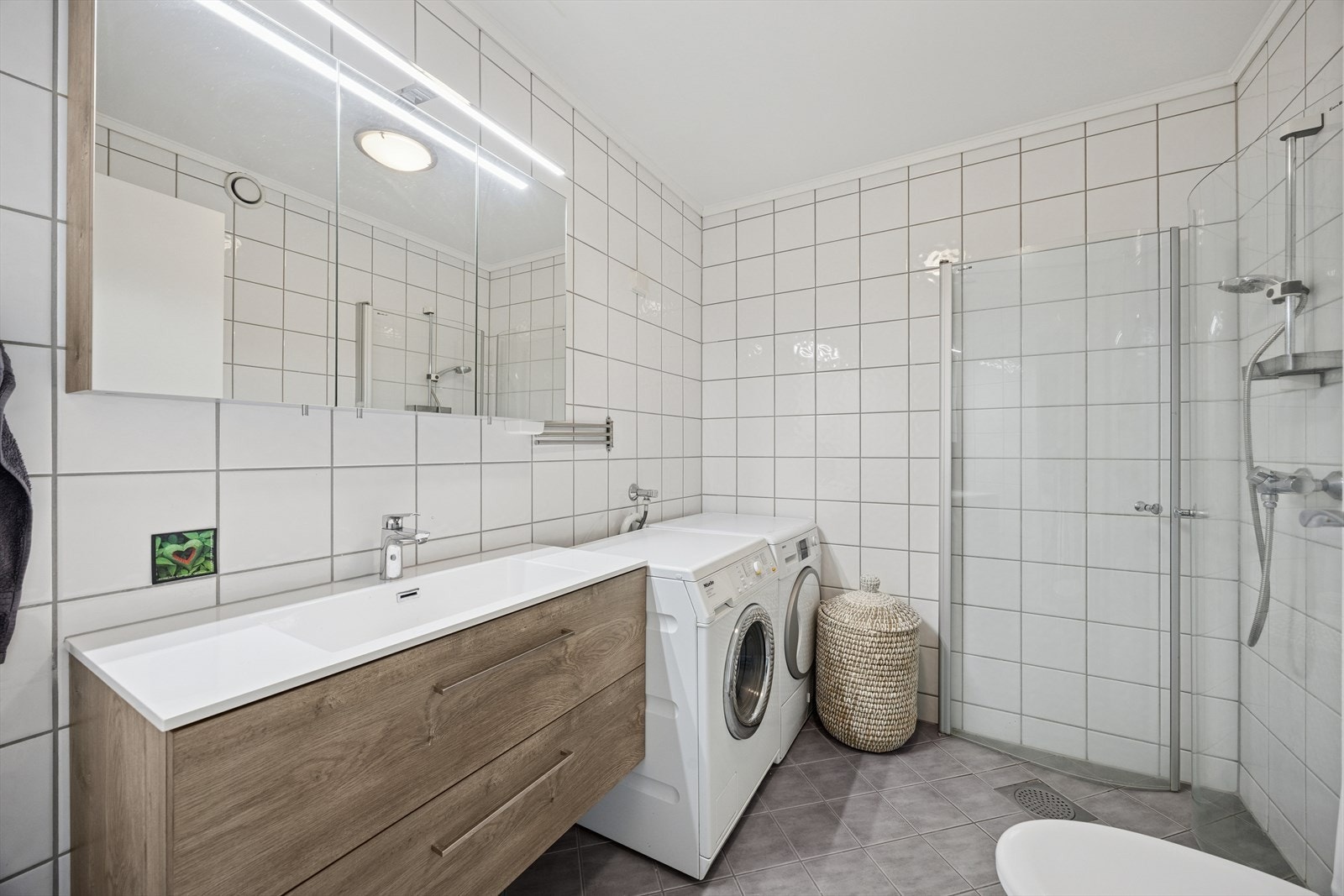 Badet har adkomst fra gangen og fremstår som både innbydende og funksjonelt. Våtrommet er fra byggeåret (2008) og har mekanisk avtrekk. Galleribilde