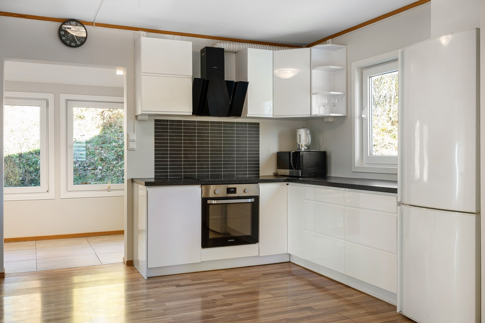 Pent og tidløst kjøkken med slette fronter og laminat benkeplate Galleribilde