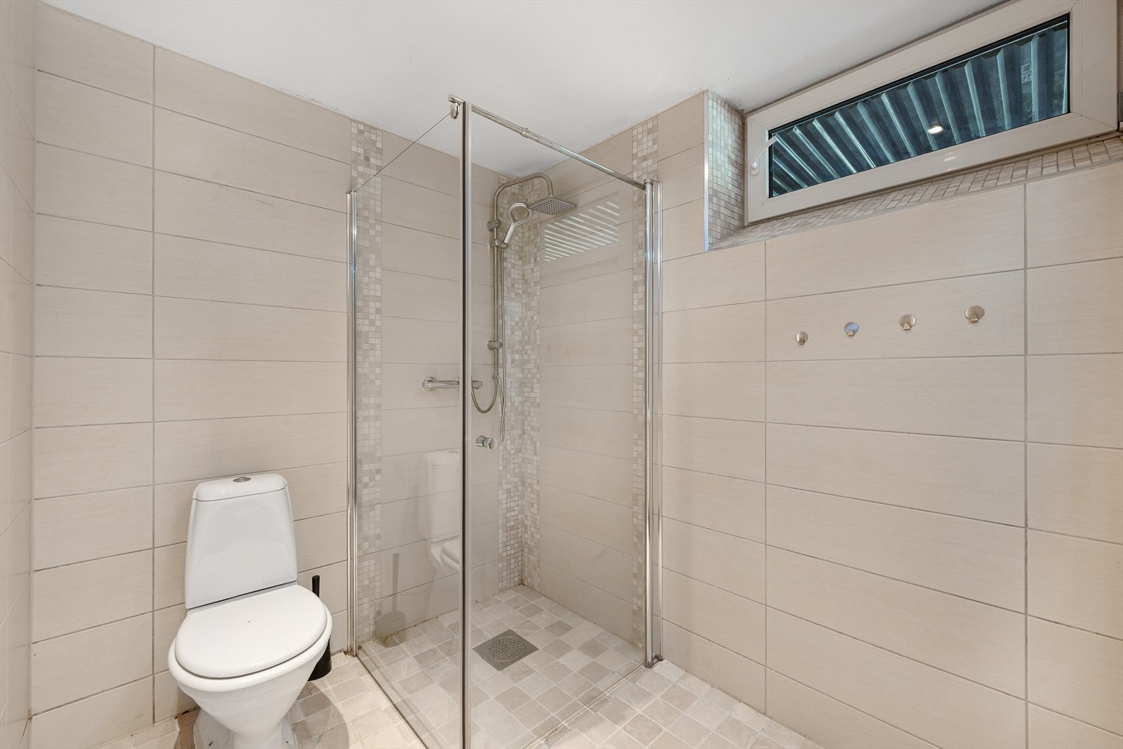 Pent flislagt bad fra 2015 som inneholder dusjnisje, wc og vask m/baderomsinnredning. Galleribilde