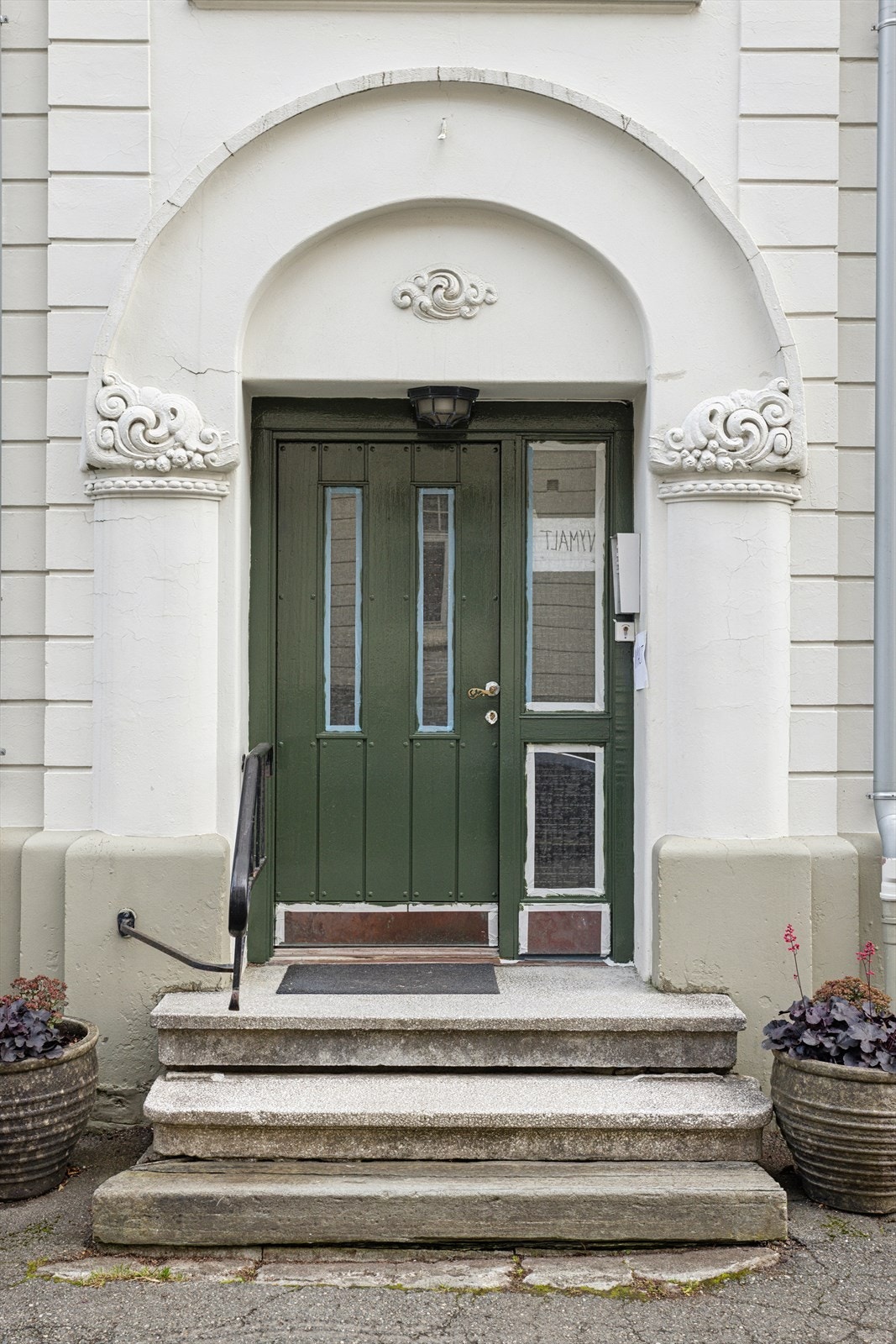 Ytterdøren har en klassisk malt utførelse med dekorative detaljer, i stil med resten av bygget. Galleribilde