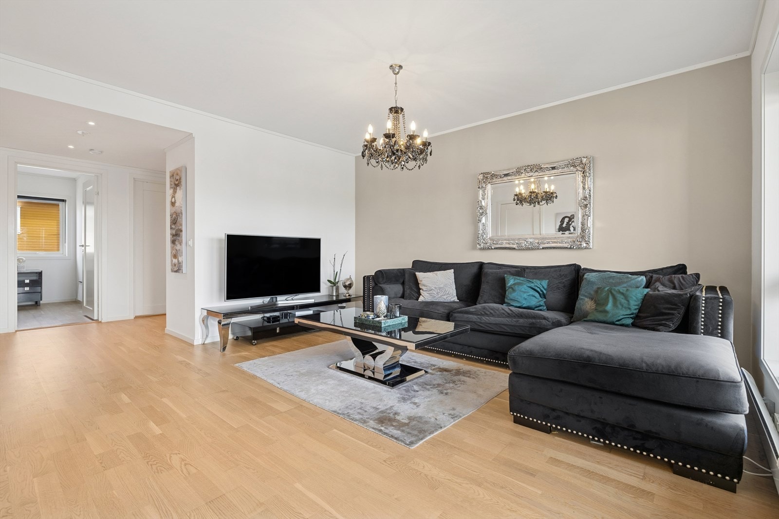 Videre byr stuen på lyse overflater, parkettgulv og himling er lyssatt med lampe. Galleribilde