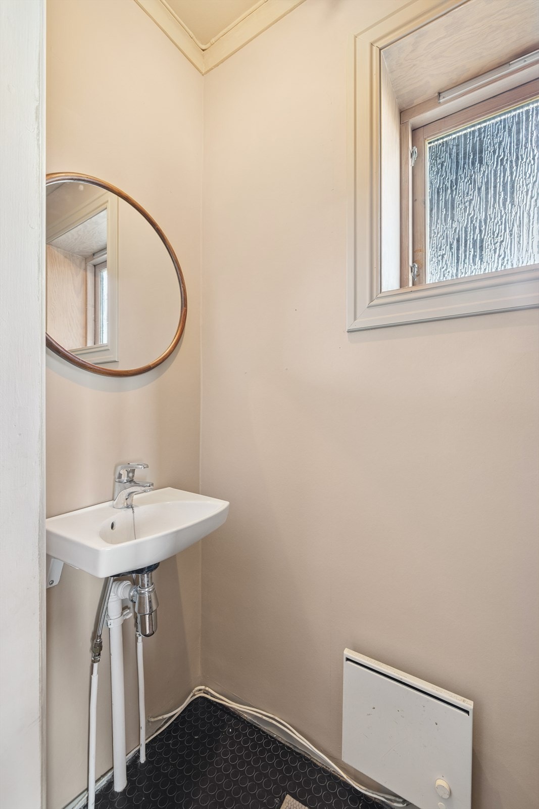 Toalettrommet har belegg på gulv, malte vegger og tak, og er innredet med en enkel vask og et standard toalett. Rommet har naturlig ventilasjon. Galleribilde