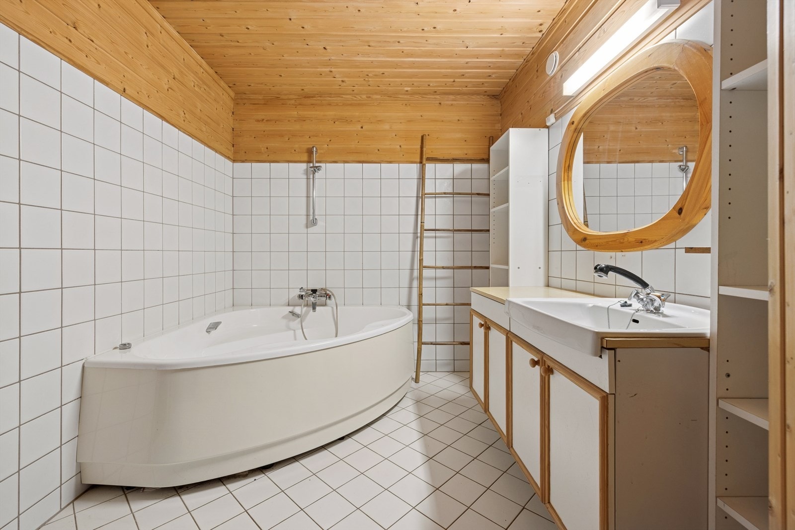 Badet i underetasjen er gjennomført med flislagt gulv, samt en kombinasjon av fliser og panel på veggene. Rommet er innredet med boblekar, badstue og baderomsinnredning med heldekkende servant og skap, sideskap og belyst speil. Galleribilde