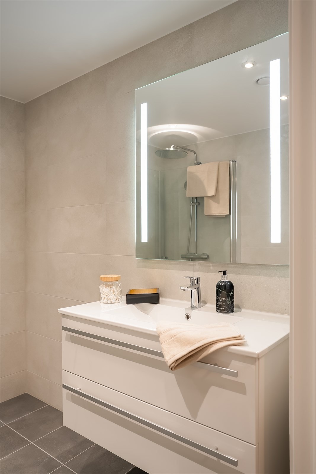 Servantskapet er levert med skuffer og helstøpt servantplate. Speilet har integrert LED belysning og det er dimbare downlights i taket. Galleribilde