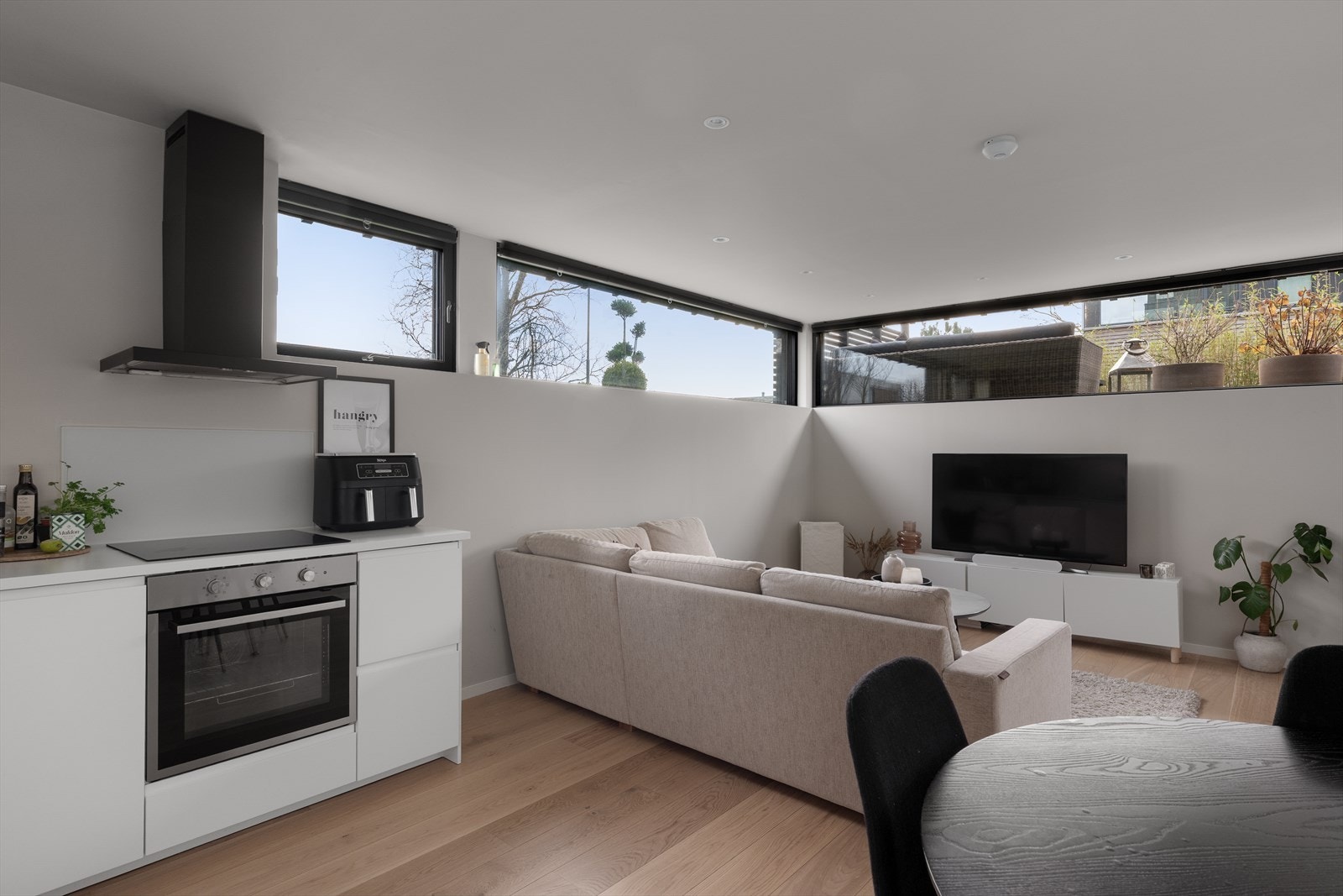 Hybelen er innredet med et tidløst kjøkken i åpen løsning med stuen Galleribilde