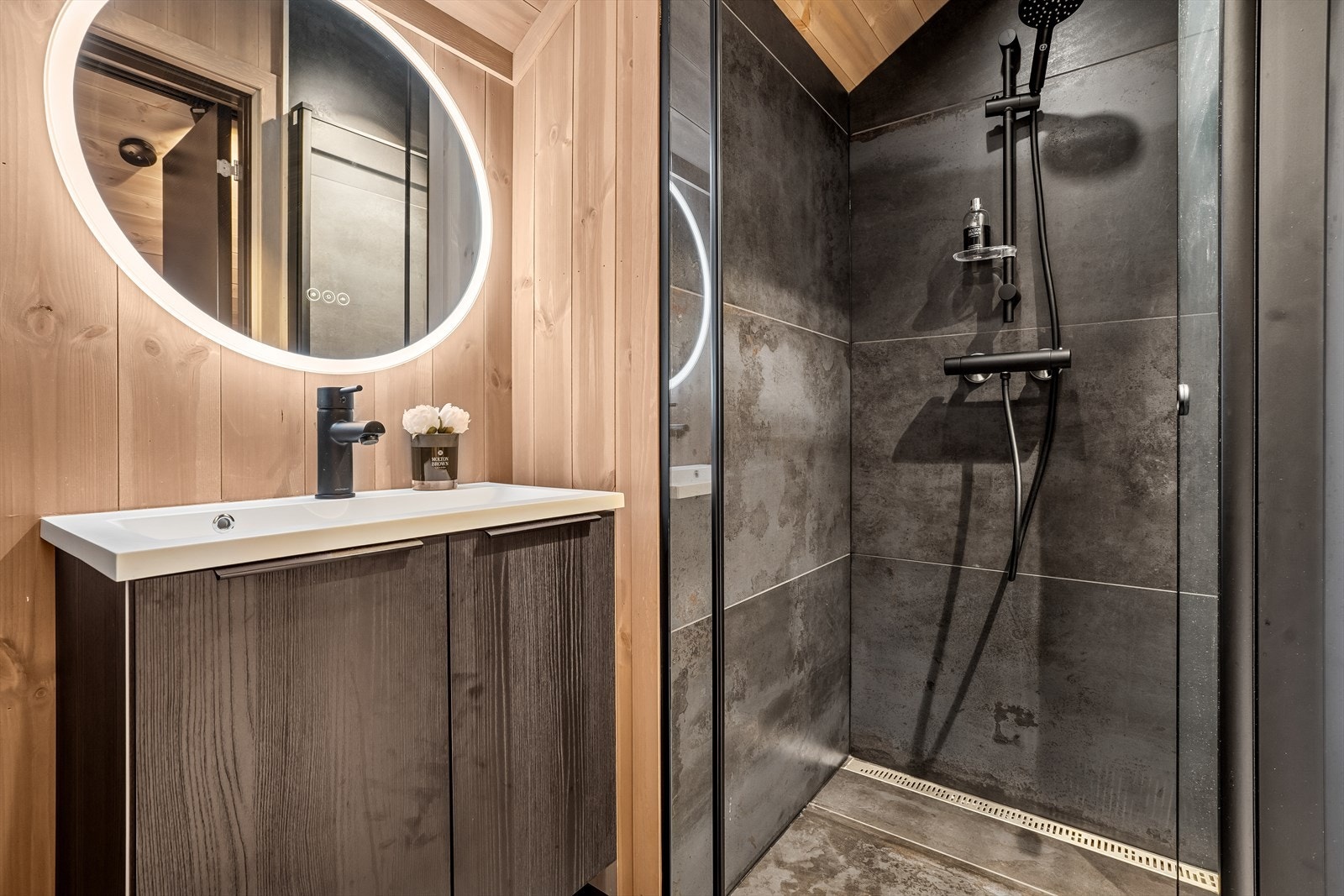 Badet på hemsen har innredning med nedfelt servant, veggmontert toalett og dusjvegger/hjørne. Galleribilde