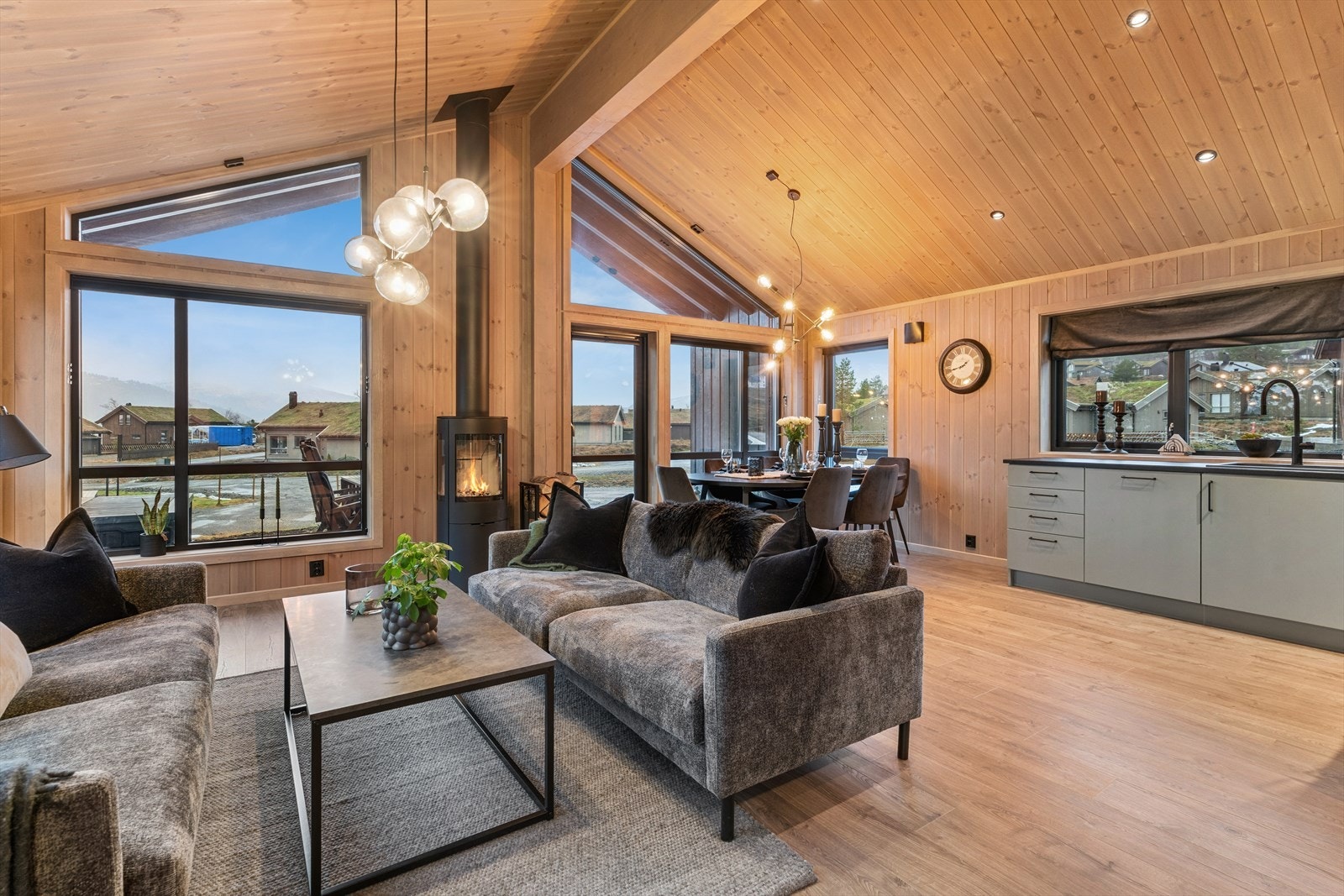 Vidare innover i hytta kjem du inn i stova/kjøkkenet med mønehøgt tak og fleire vindaugsflater. Her har du laminat på golv og beisa panel på veggar og himling. Galleribilde