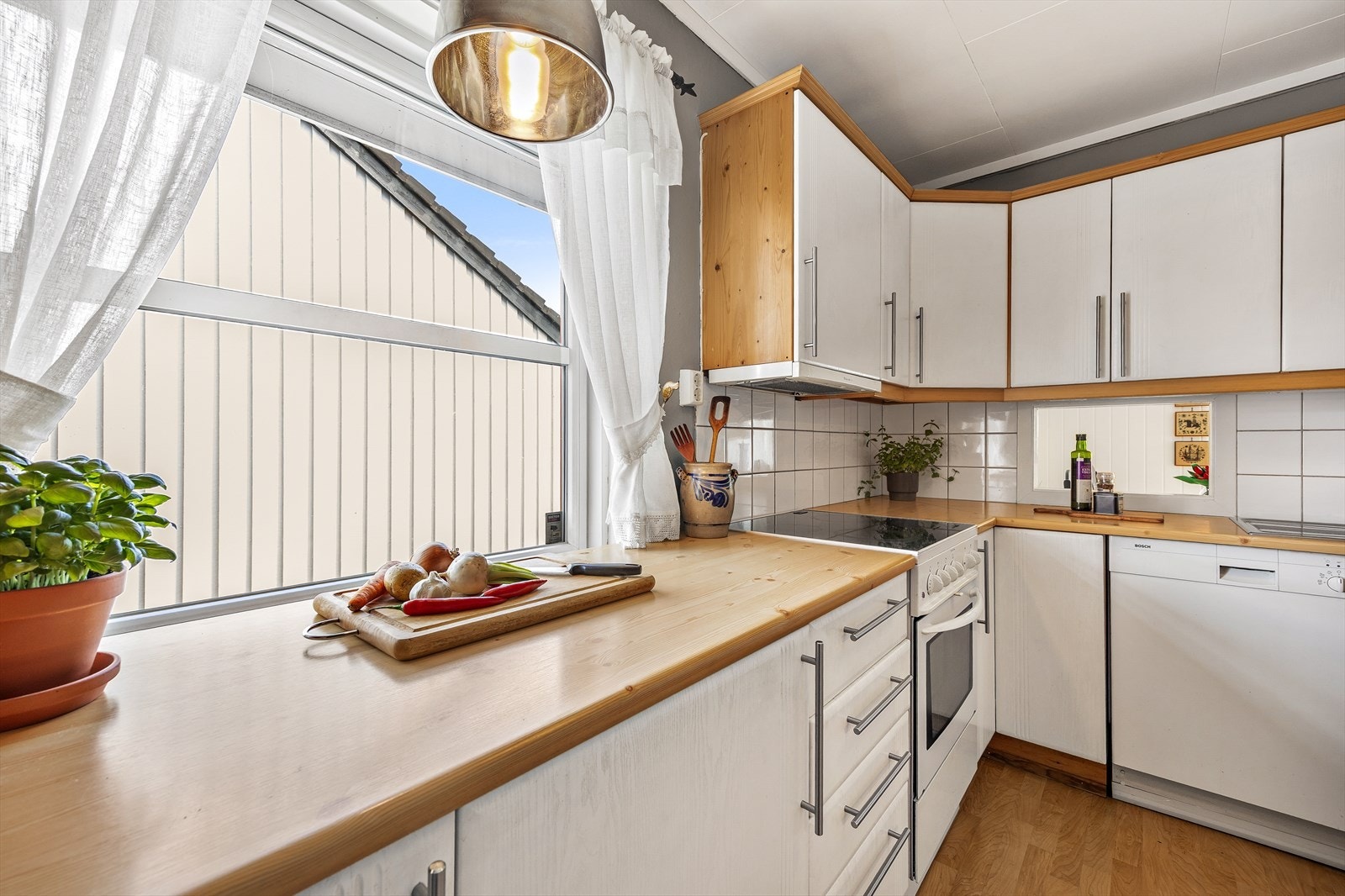 Benkeplaten i laminat gir rikelig arbeidsplass til matlaging og daglige rutiner. Galleribilde