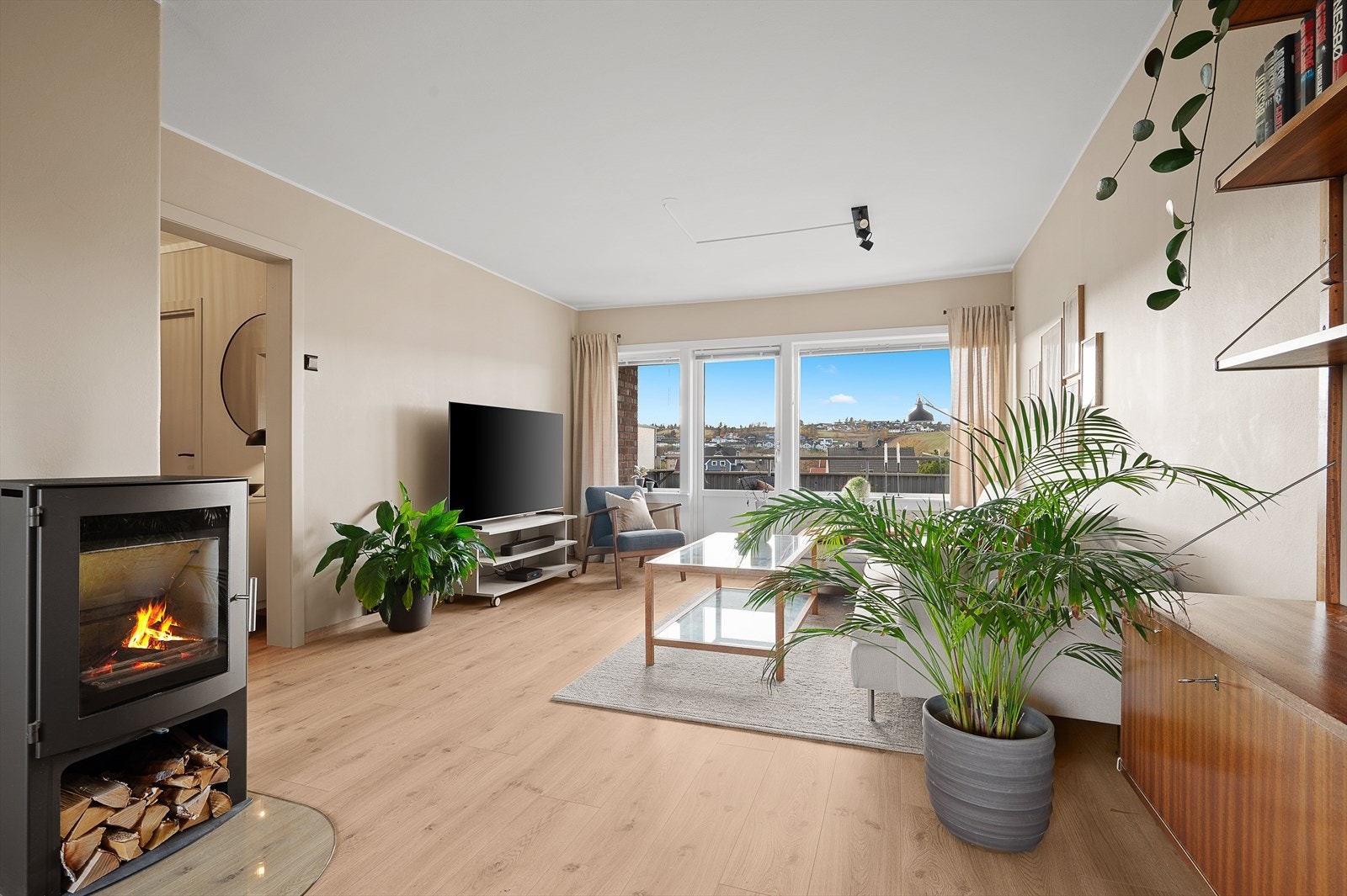 I stuen er det peis som gir leiligheten god varme og som holder strømkostnadene nede. For øvrig utgnag til solrik balkong fra stuen Galleribilde