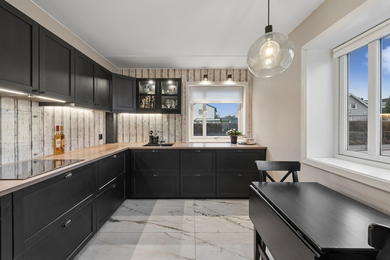 Delikat og gjennomført kjøkken med stilren IKEA-innredning fra 2019, utført i mørke profilerte fronter som gir et moderne og eksklusivt uttrykk. Galleribilde