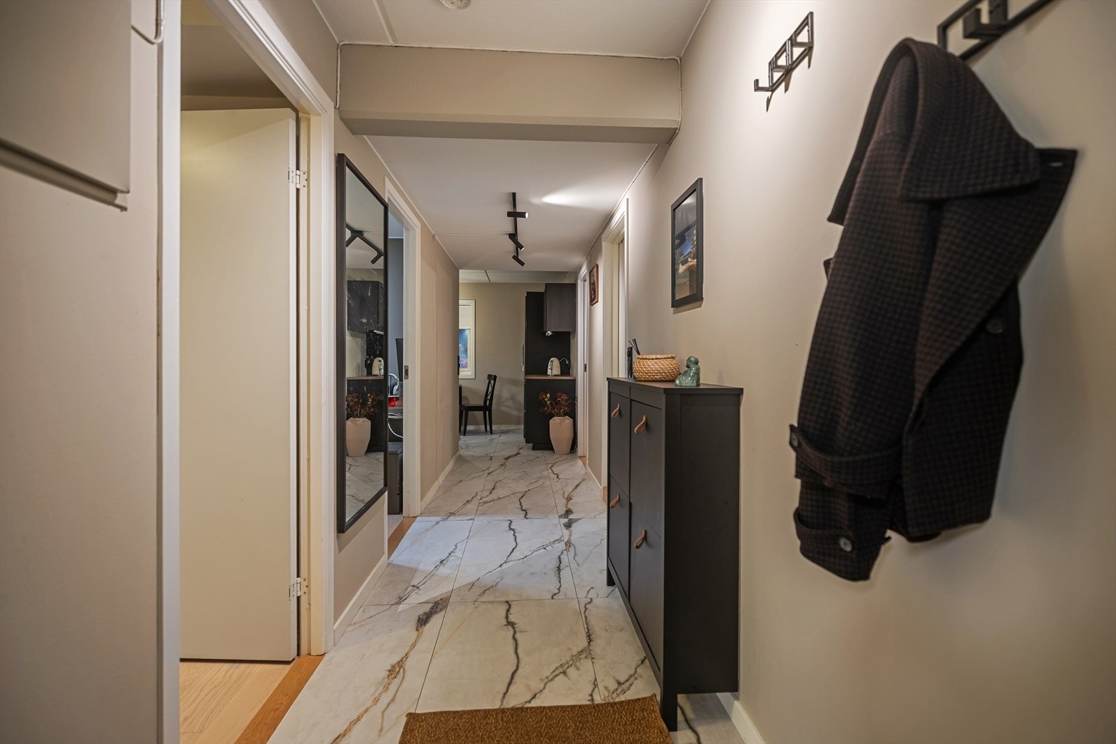 Entréen gir en ryddig og god adkomst videre til leilighetens øvrige rom og bidrar til et helhetlig og gjennomtenkt førsteinntrykk. Galleribilde