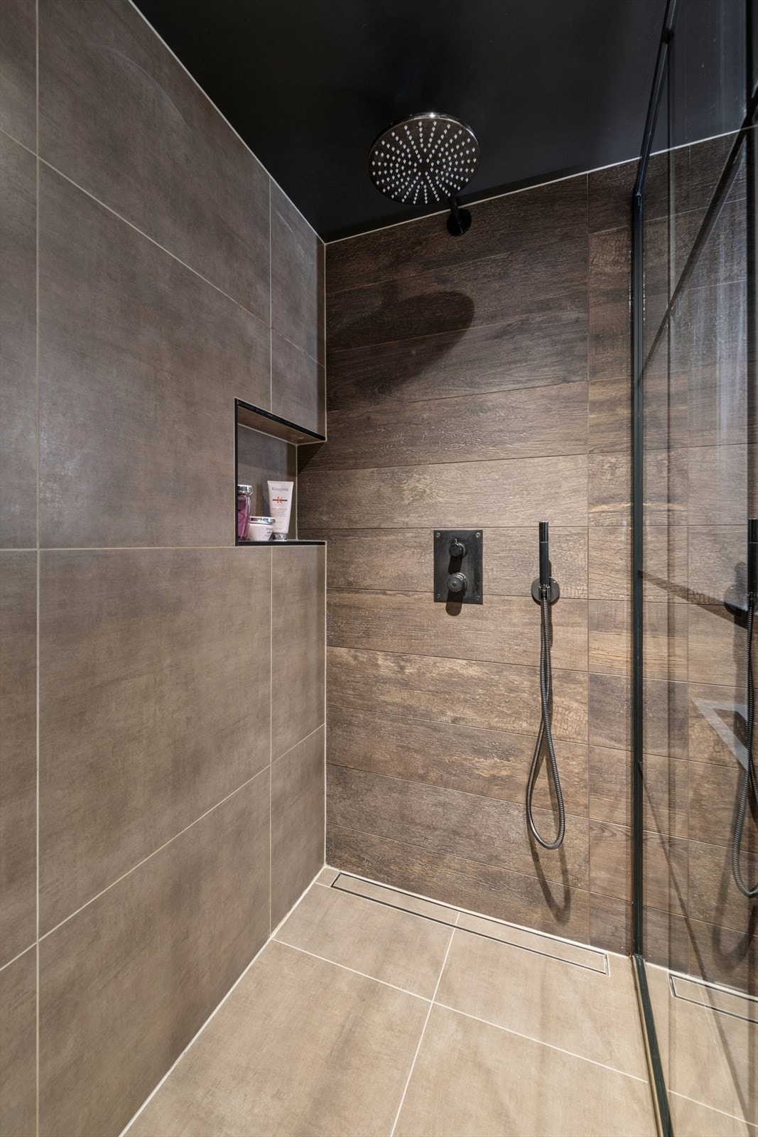 Dusjhjørnet er utført med fastmontert glassvegg, regndusj og veggmontert armatur, samt praktisk nisje for oppbevaring. Galleribilde