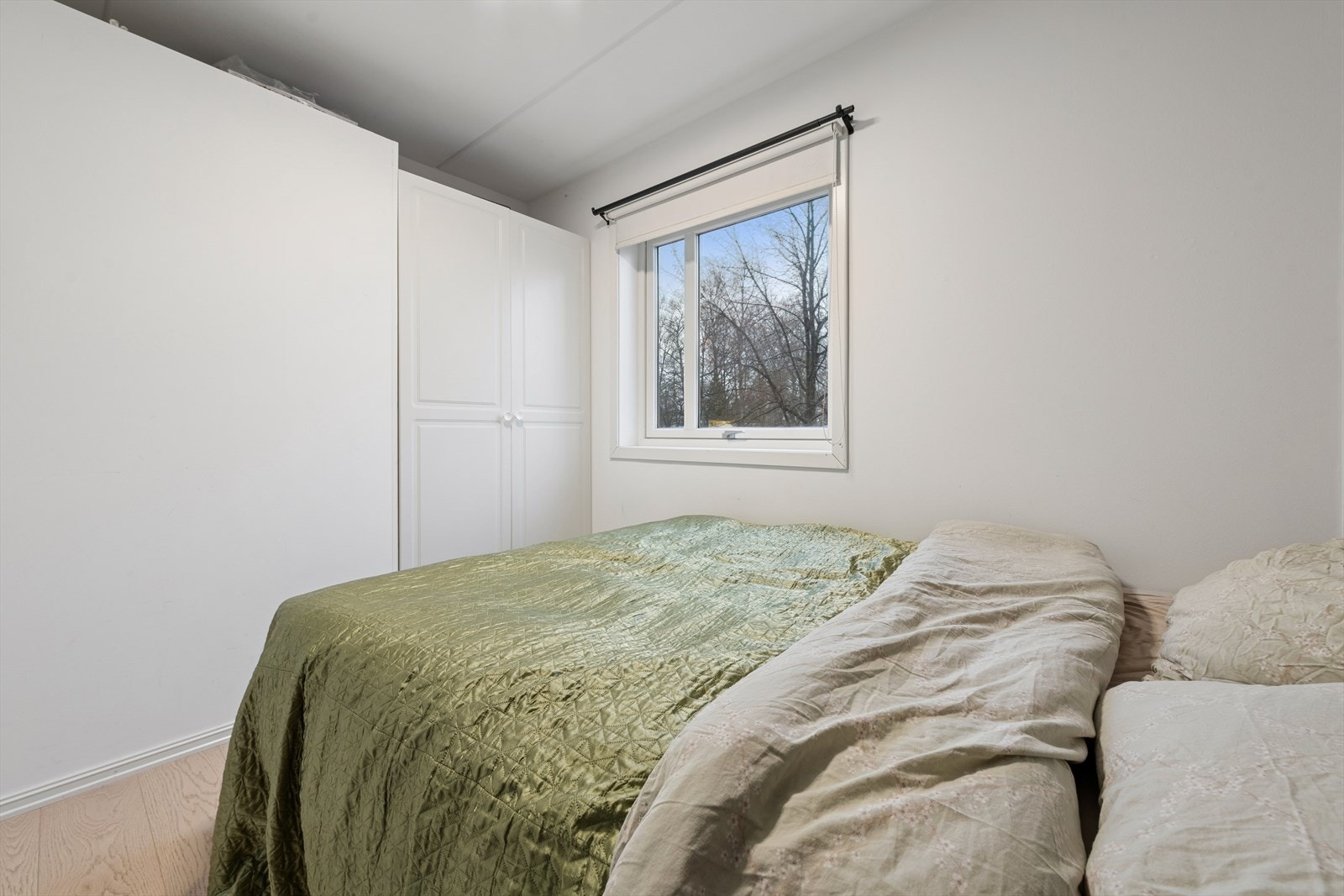 Praktisk soverom med garderobeløsning og vindu som slipper inn dagslys. Galleribilde