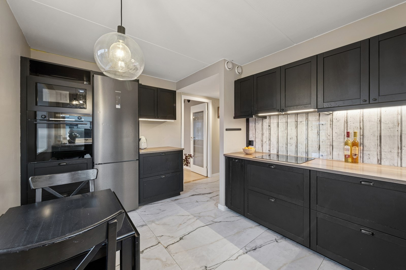 Kjøkkenet er utstyrt med integrerte hvitevarer, herunder induksjonstopp, stekeovn, mikrobølgeovn og oppvaskmaskin, samt frittstående kjøle-/fryseskap. Galleribilde