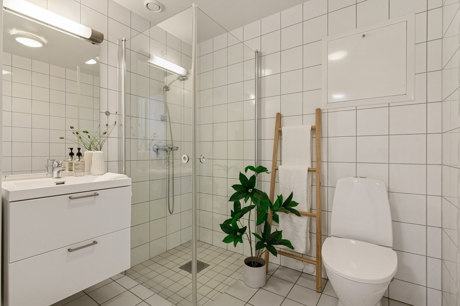 Badet er utstyrt med servant, toalett og dusjvegger/hjørne Galleribilde