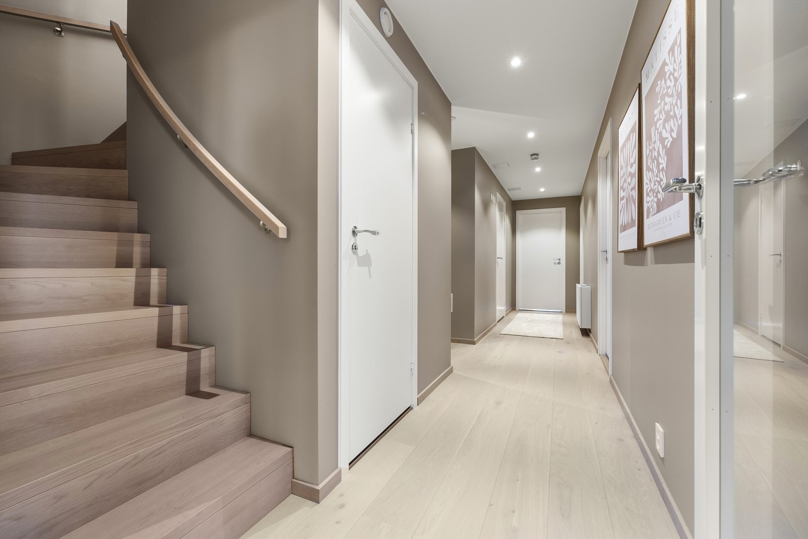 Gjennomgående lys eikeparkett og en solid trapp som forbinder leilighetens to plan. Galleribilde