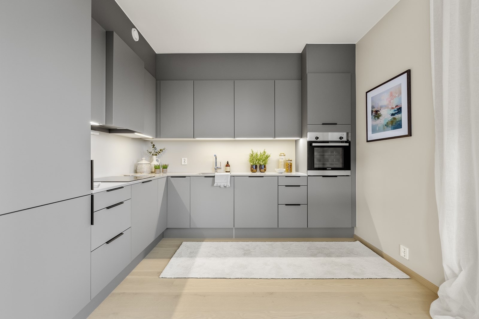 Kjøkkeninnredning med slette, grå fronter og integrerte hvitevarer. Galleribilde