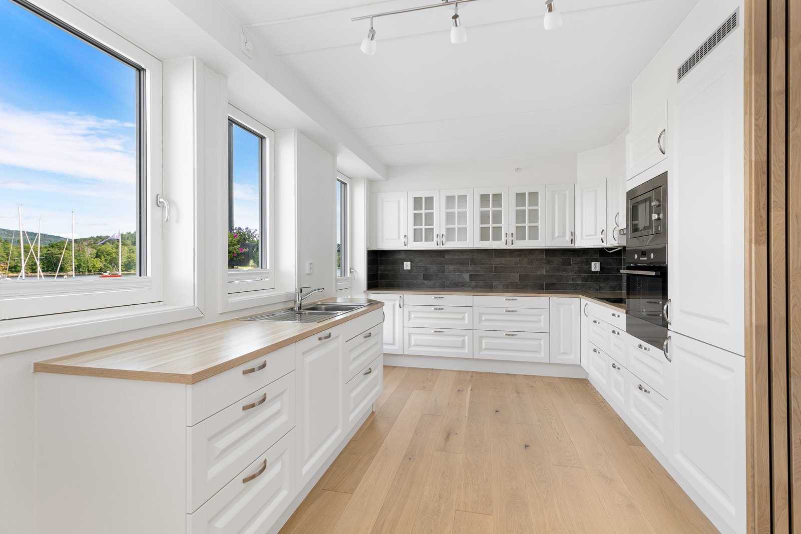 Kjøkkenet har kjøkkeninnredning med hvite profilerte fronter fra merket Aubo Galleribilde