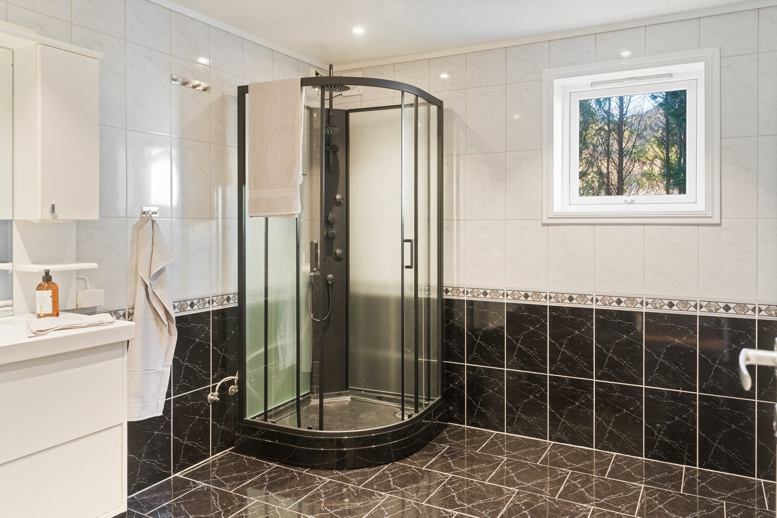 Bad i kjeller med flislagt gulv, varmekabler og dusjkabinett. Galleribilde