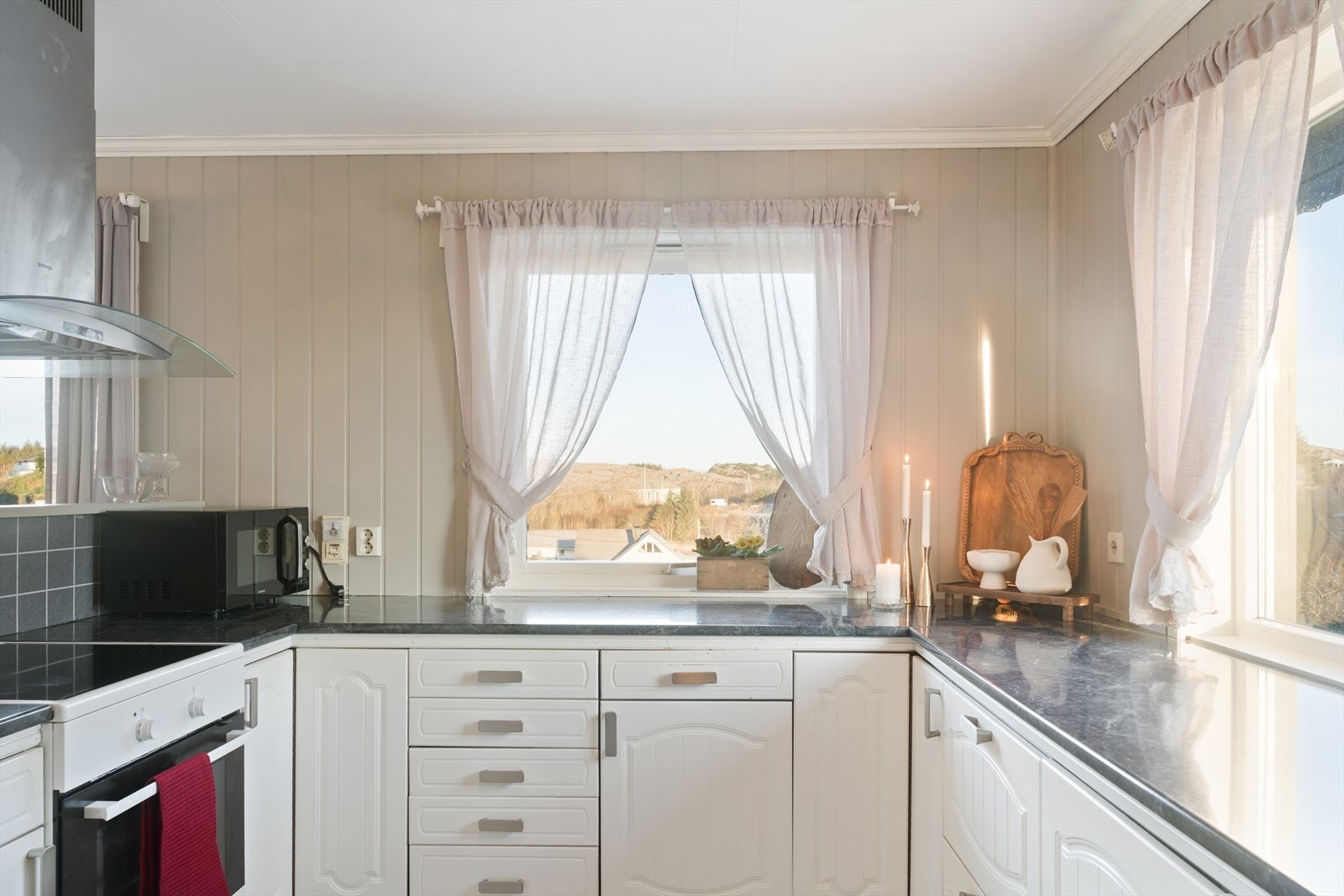 Kjøkkeninnredning med hvite profilerte fronter som gir et lyst og tidløst uttrykk. Galleribilde