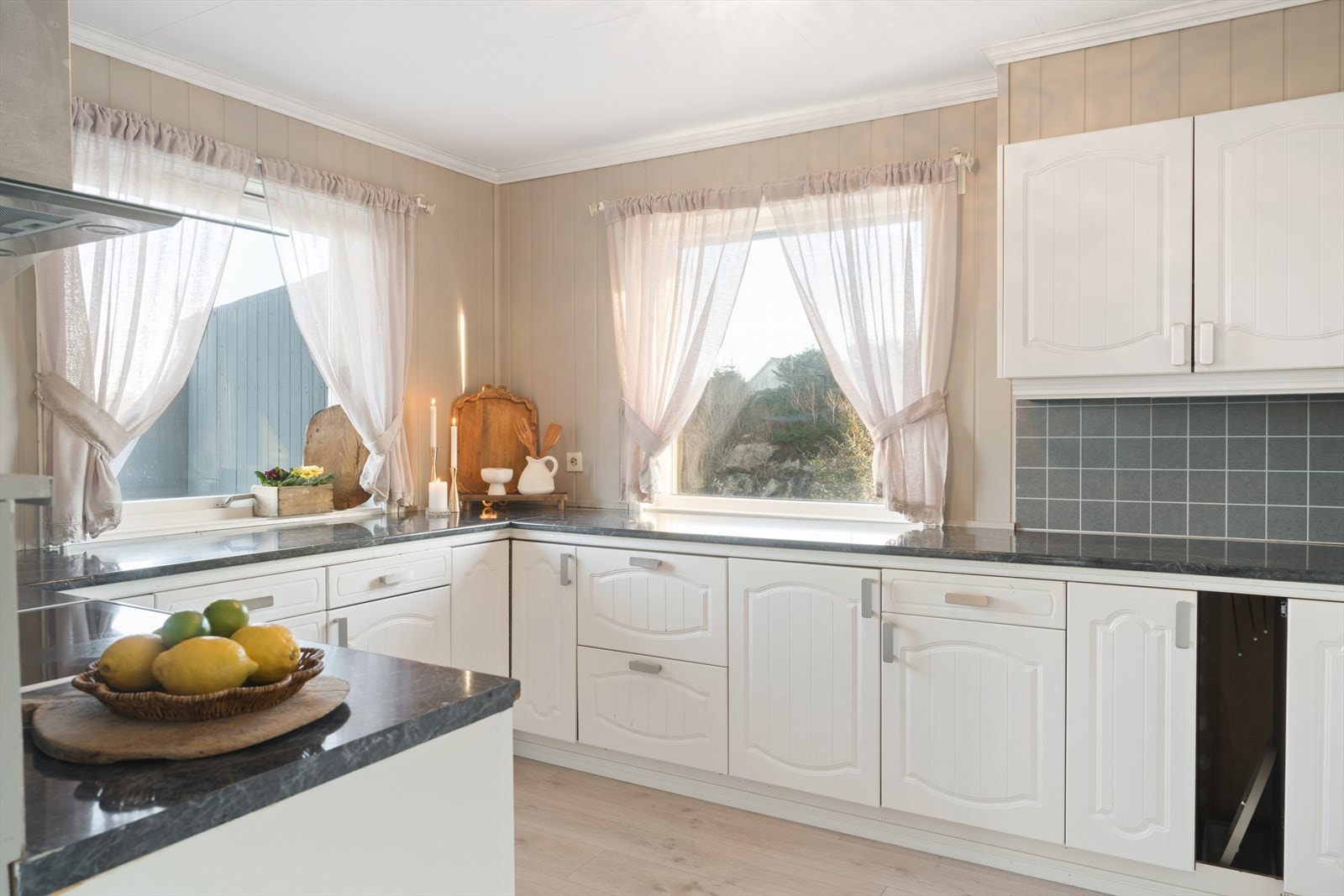 Godt lysinnslipp fra vinduer bidrar til en lys og trivelig kjøkkenplass. Galleribilde