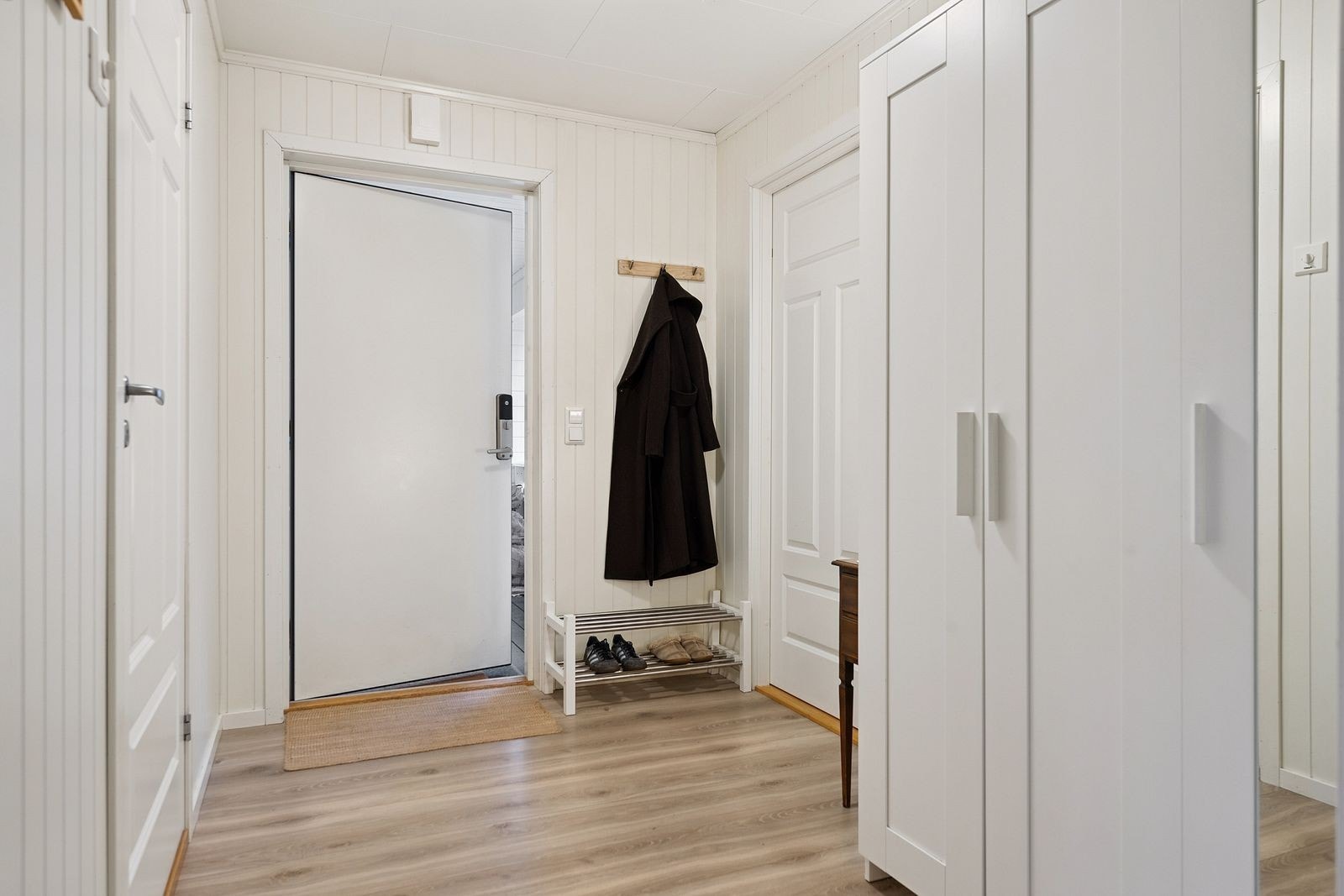 Romslig entré med plass til garderobeskap og skohylle. Galleribilde
