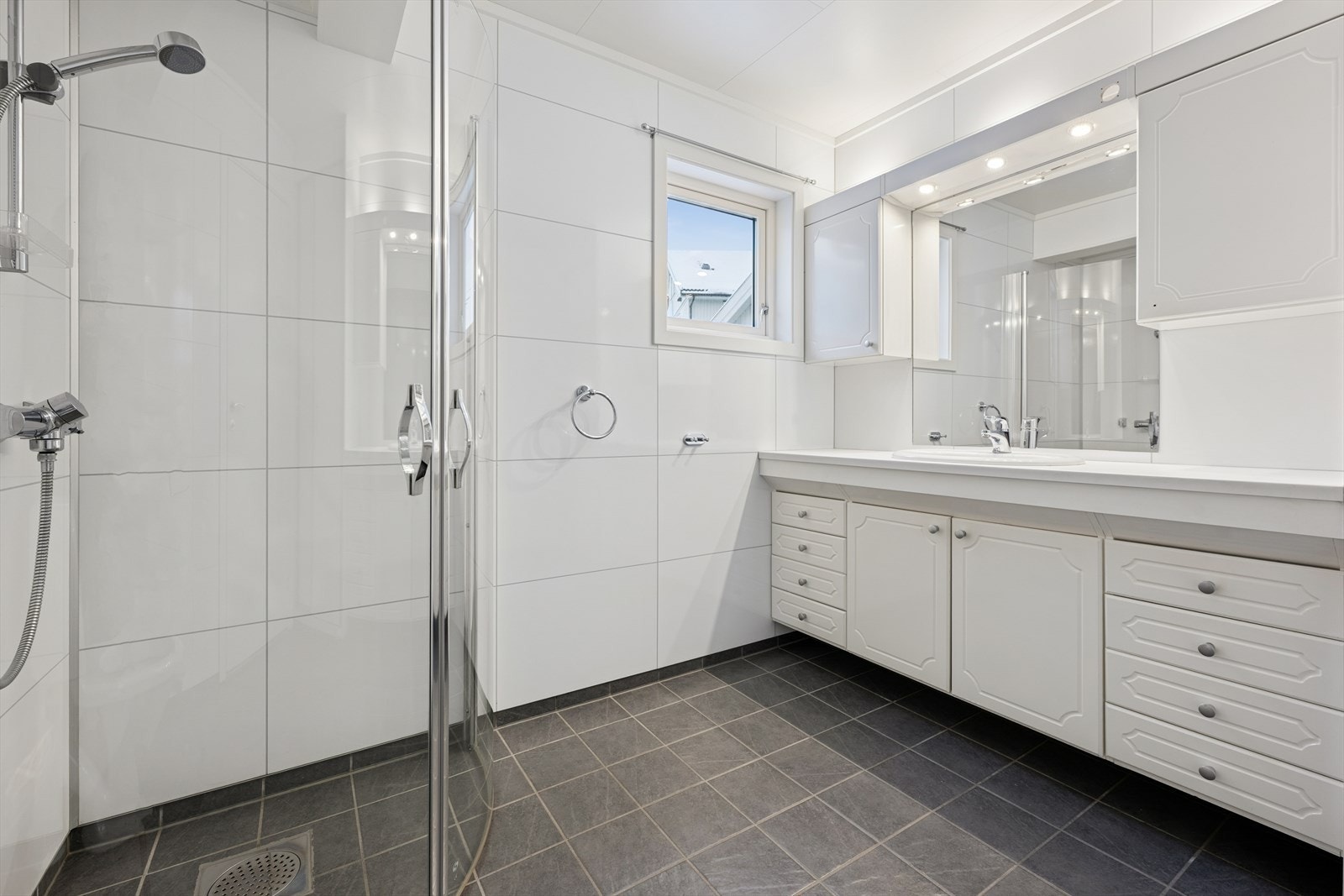 Baderom fra 2016 med flislagt gulv og elektriske varmekabler. Galleribilde