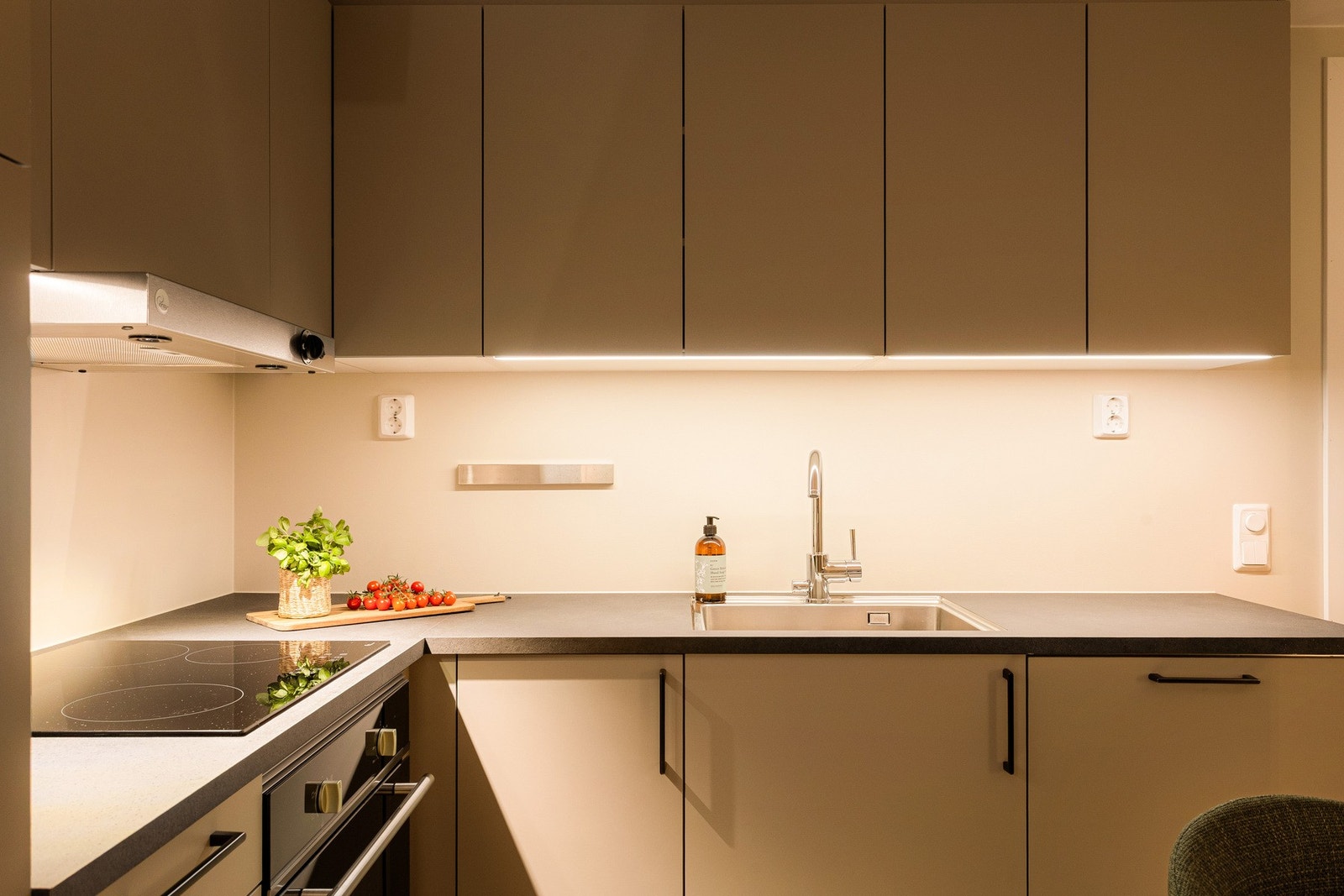 Kjøkkenet er utstyrt med integrerte hvitevarer, inkludert innfelt kjøleskap, komfyr med induksjonstopp og opplegg for oppvaskmaskin. Galleribilde