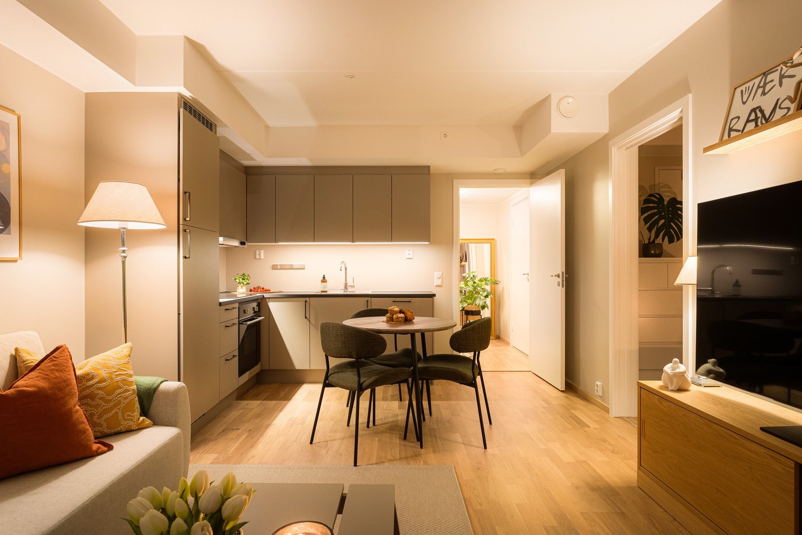 Lyse veggflater harmonerer elegant med parkettgulvet og skaper en stilren og tidløs ramme. Galleribilde