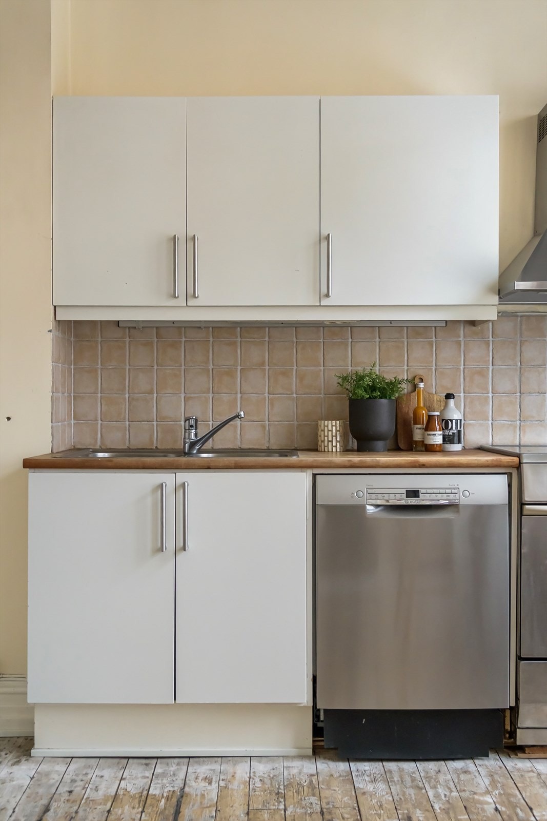 Kjøkkenet har hvite slette fronter og benkeplate av heltre. Galleribilde