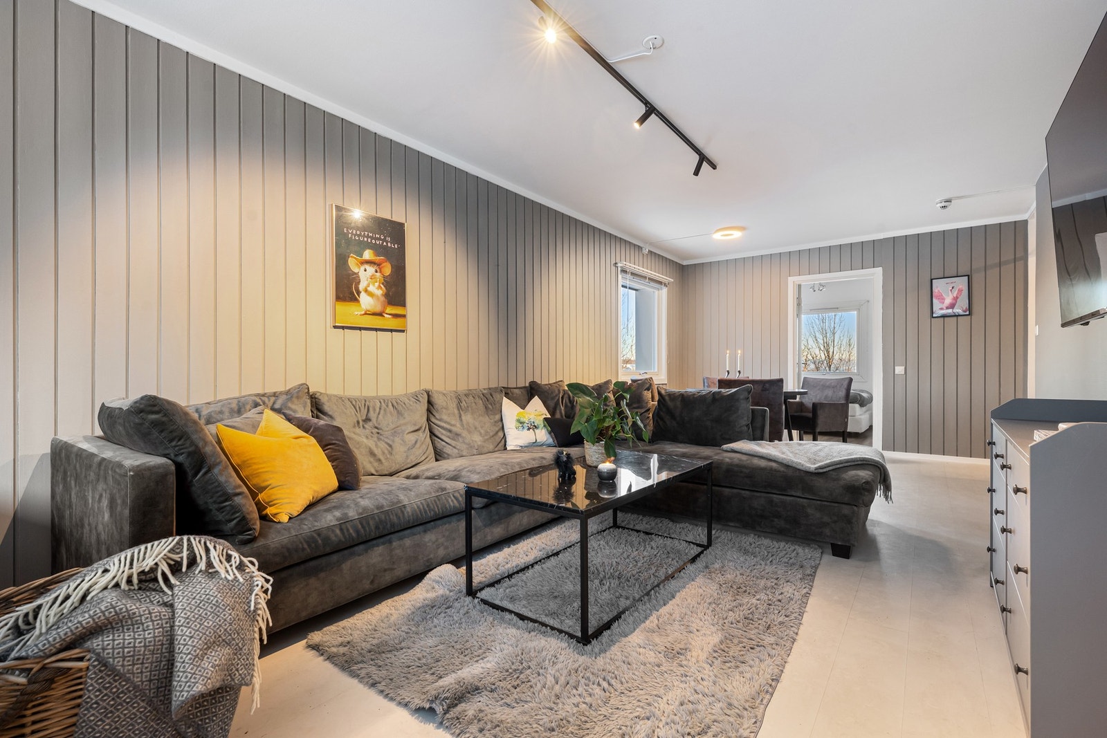 en innbydende, lys og luftig stue med god plass til både en komfortabel sofagruppe og en romslig spisestue - perfekt for både hverdagsliv og sosiale sammenkomster. Galleribilde