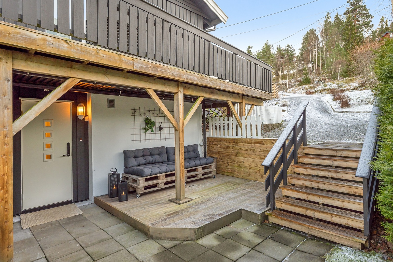 Inngangspartiet er overbygget og plattingen har plass til en liten sittegruppe. Galleribilde