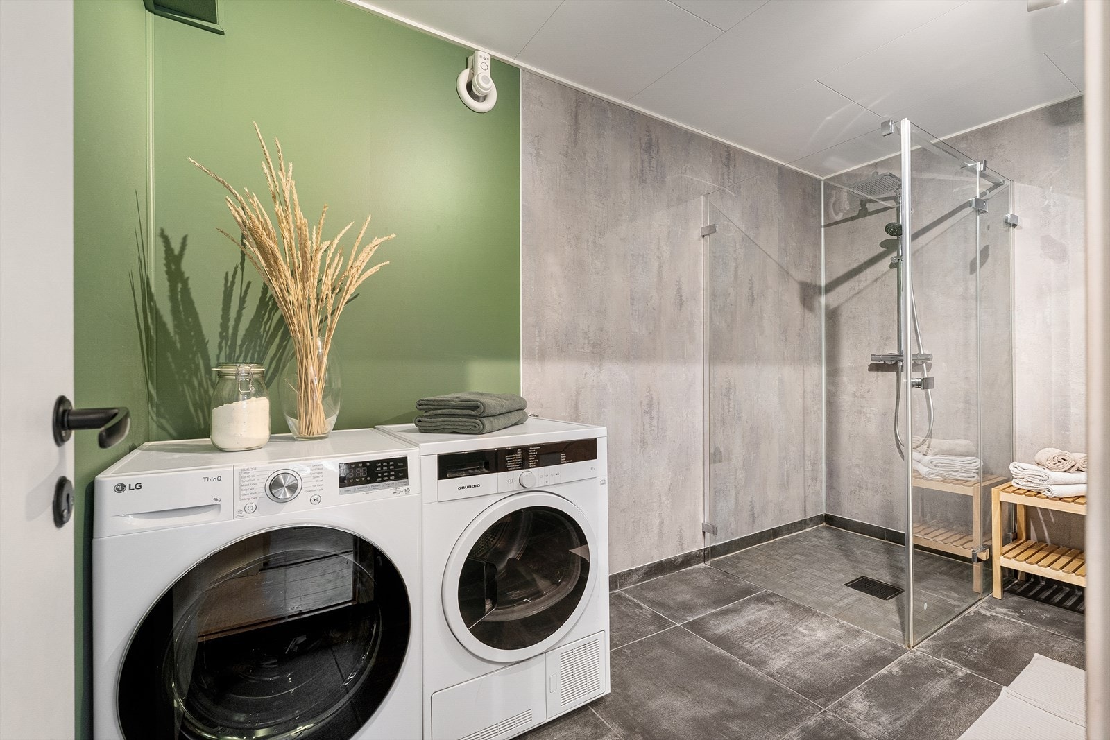 Baderommet på 8,3 m² har en lekker utførelse med en kombinasjon av baderomsplater og mørk flis, noe som gir et moderne uttrykk. Det delikate badet ble pusset opp i 2020/2021. Galleribilde