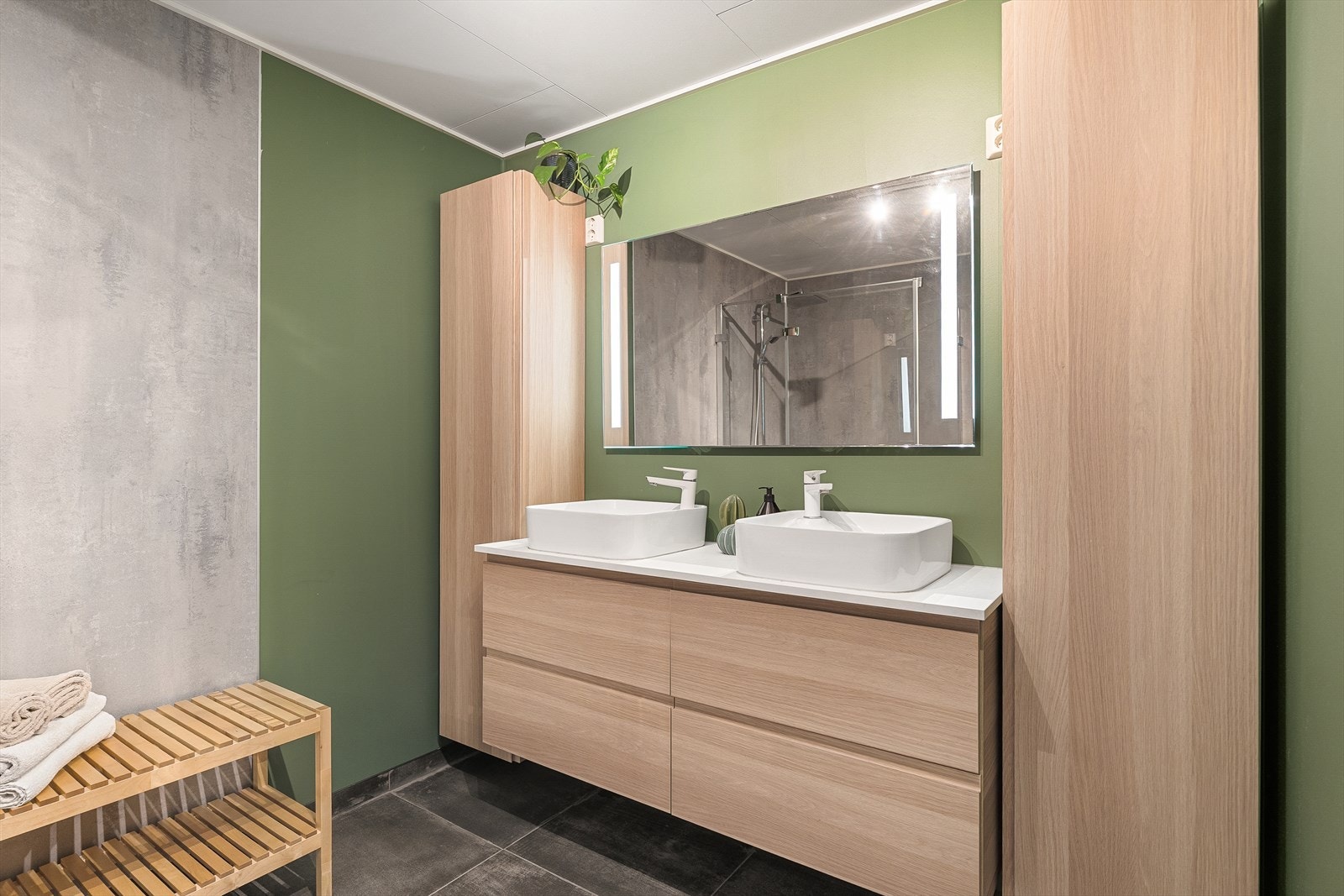 Rommet for velvære er utstyrt med dusjhjørne med glassdør, vaskemaskin, dobbelservant med underskap, veggskap og speil. Vegg-i-vegg er det et eget toalettrom. Galleribilde