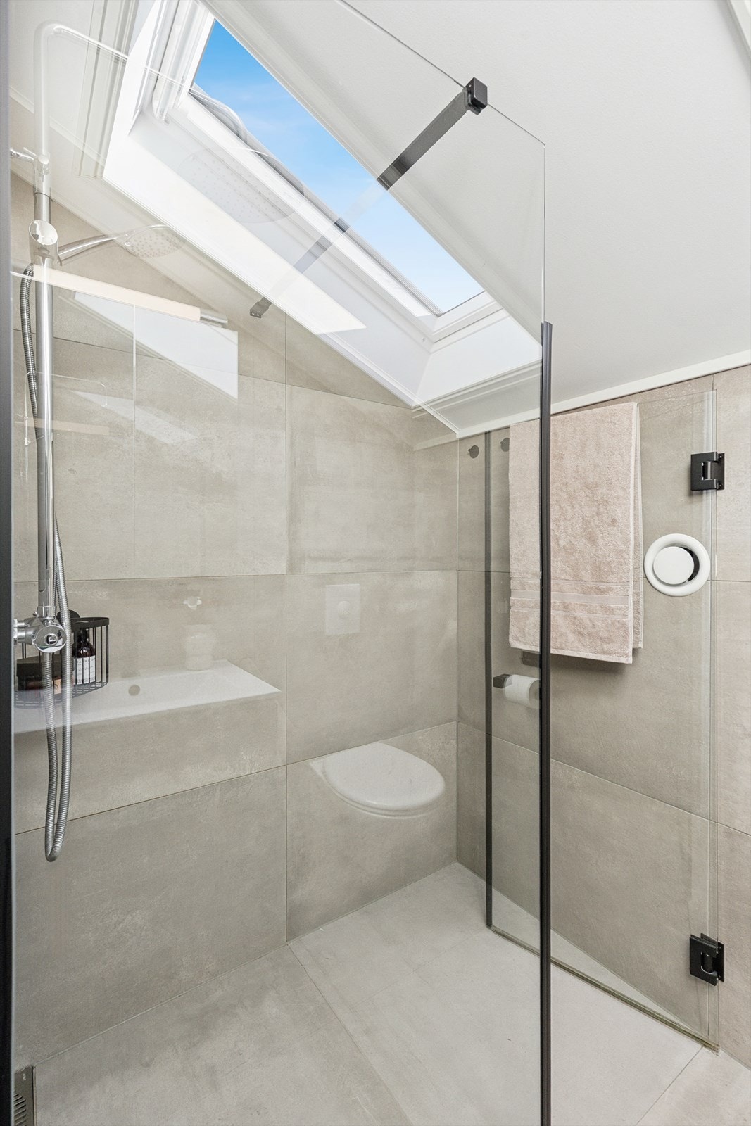 Dusjområdet har glassvegger og glassdører, og veggmontert dusjsett med både hånd- og regndusj. Galleribilde