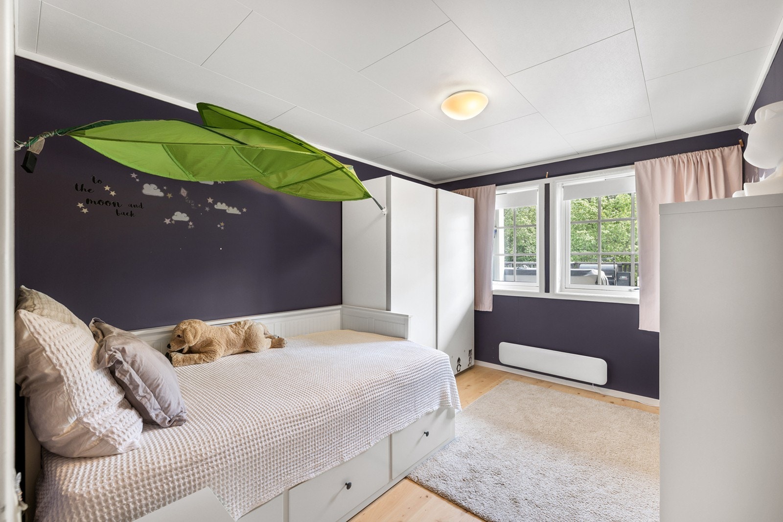 Soverom 2- Et sjarmerende og barnevennlig soverom med god plass til seng, oppbevaring og lek. Rommet har to store vinduer som gir rikelig med dagslys. Perfekt som barnerom, gjesterom eller kontor etter behov. Galleribilde