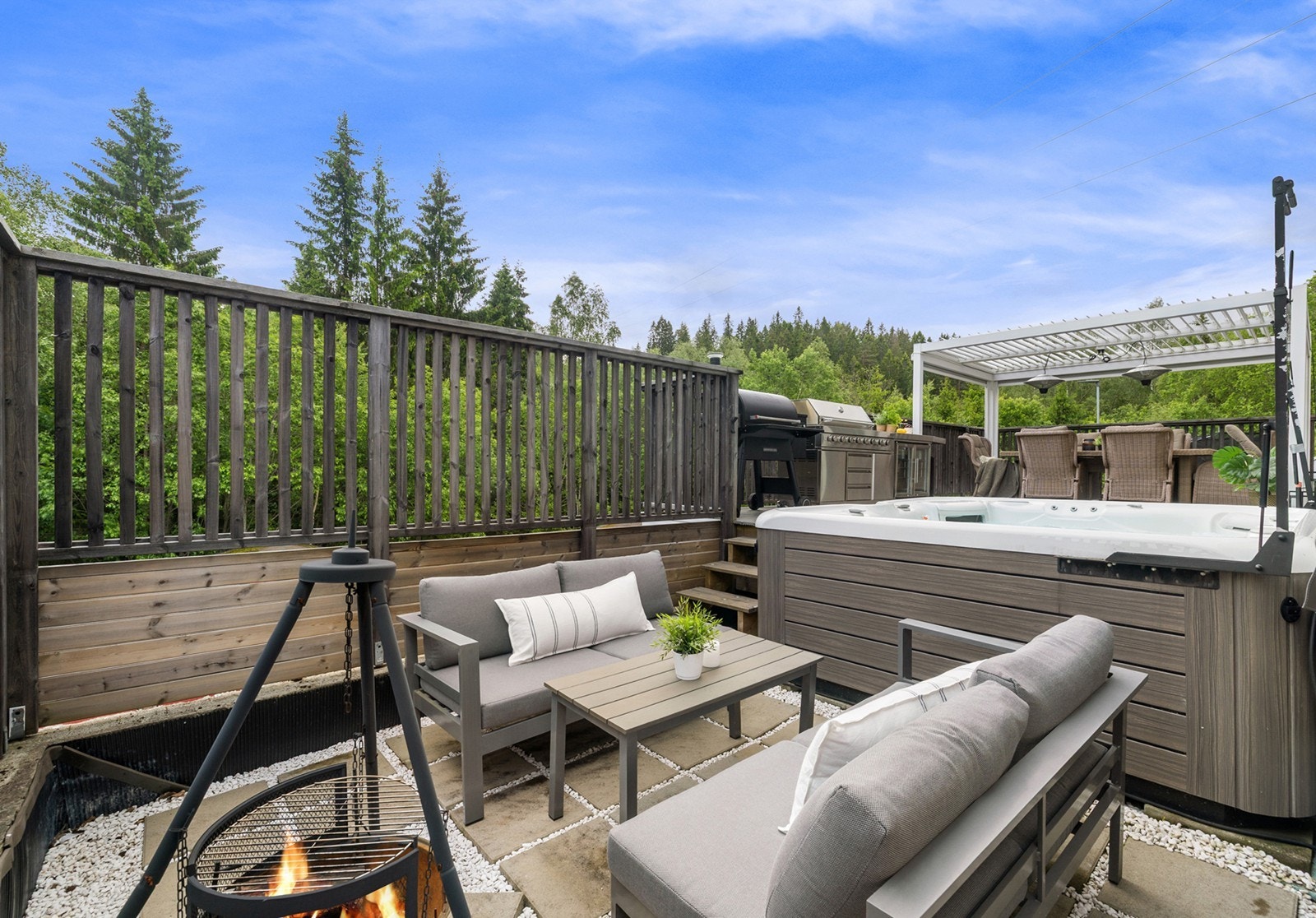 Et par trappetrinn ned leder til en steinbelagt lounge med sofagruppe - Et perfekt sted å samle venner og familie til hyggelige kvelder. Galleribilde